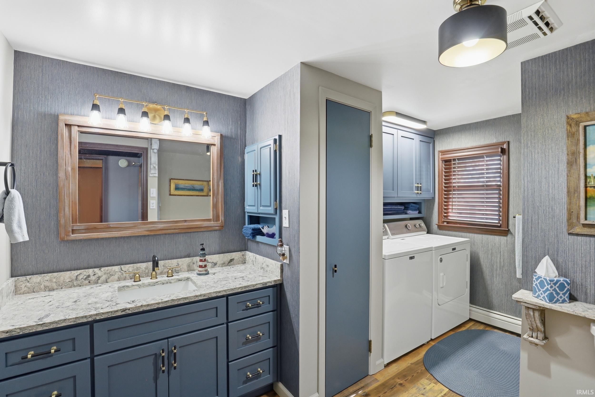 Vanity area with a wood-framed mirror and a five-light fixture