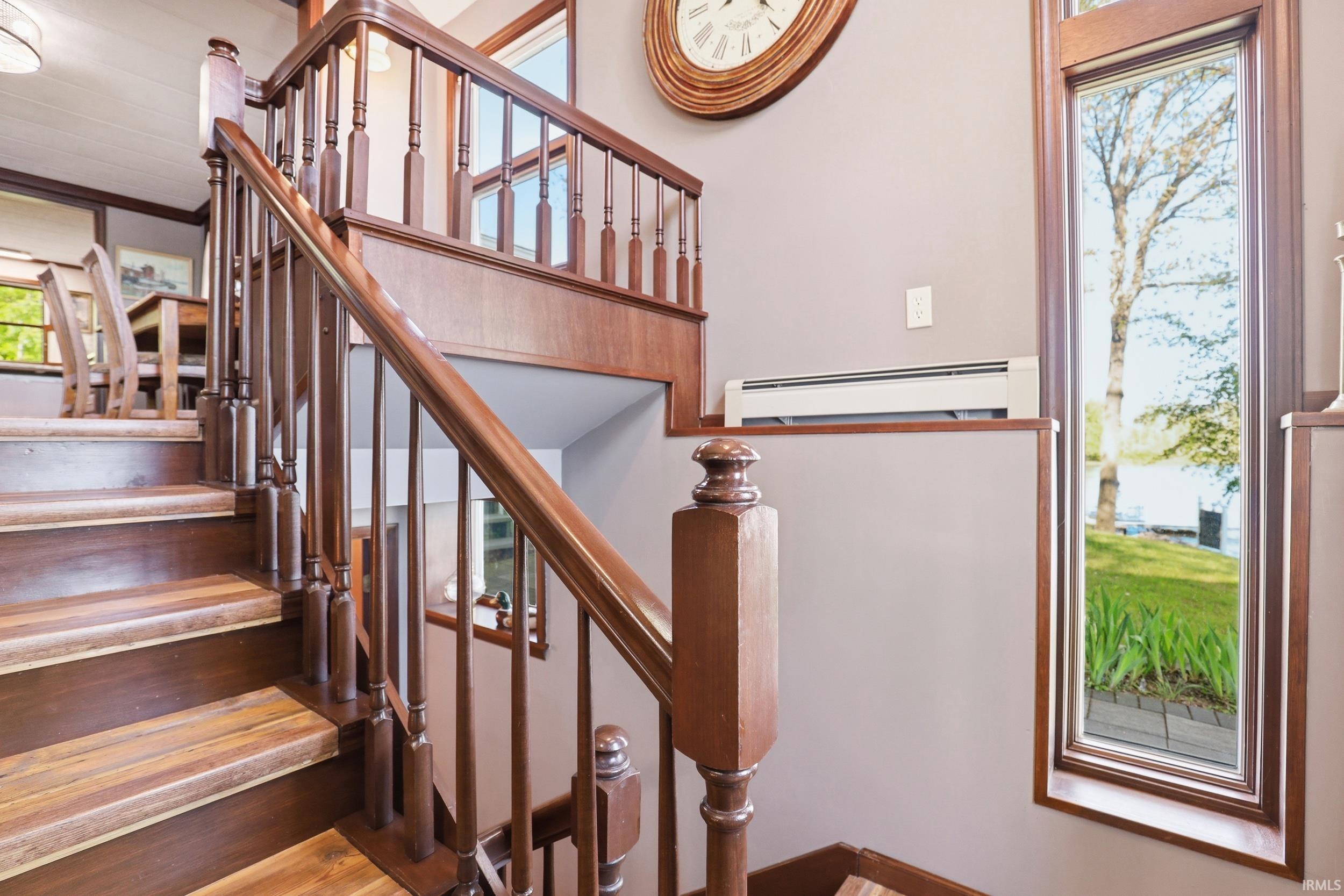 Staircase featuring wood treads and risers, turned balusters, and a polished handrail