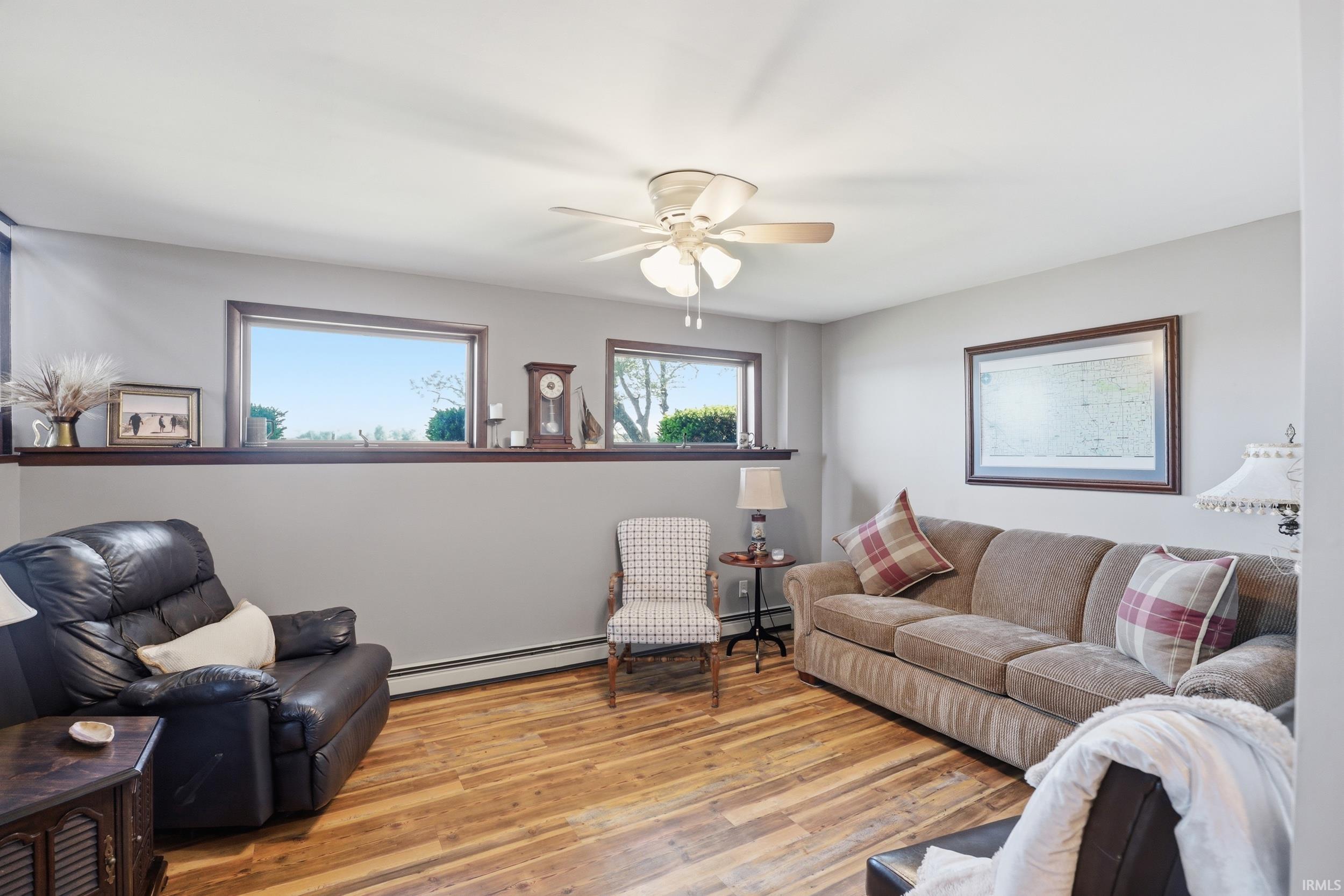 Inviting living space featuring wood-finish flooring, light gray walls, and multiple windows providing natural light