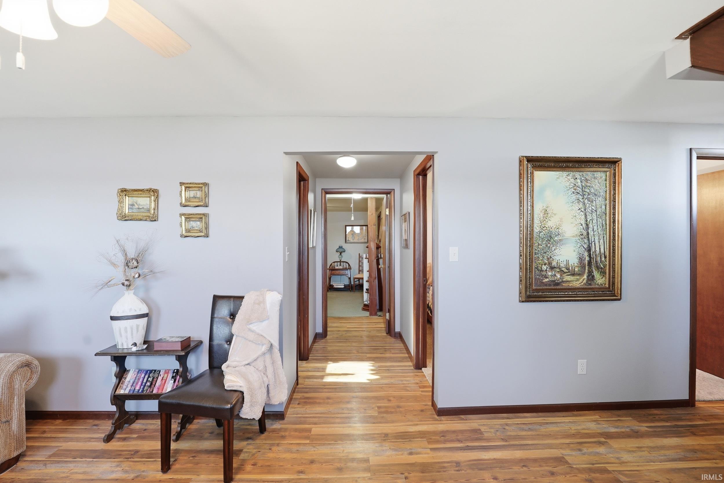 Wood-finish flooring extends throughout the space, featuring light gray walls with dark wood trim