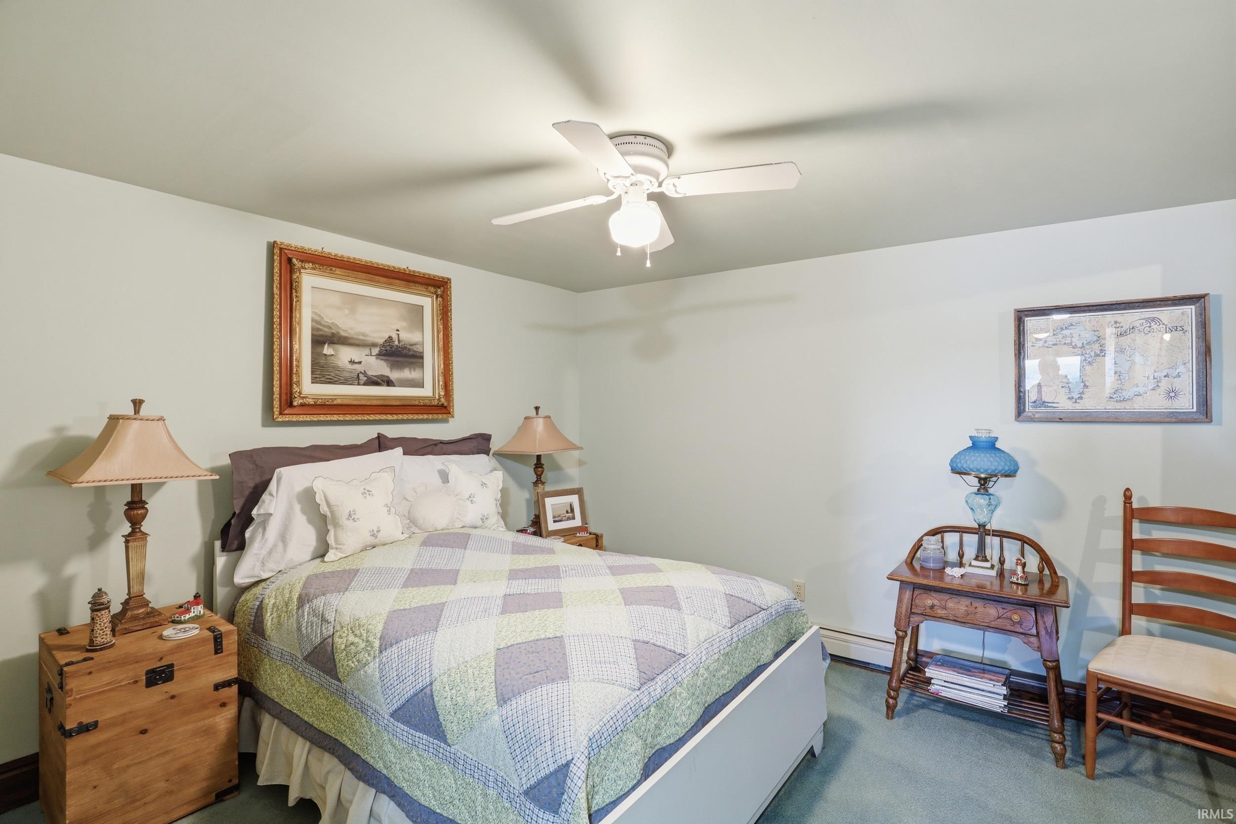 Recessed lighting, a ceiling fan, and light-colored walls define this bedroom space