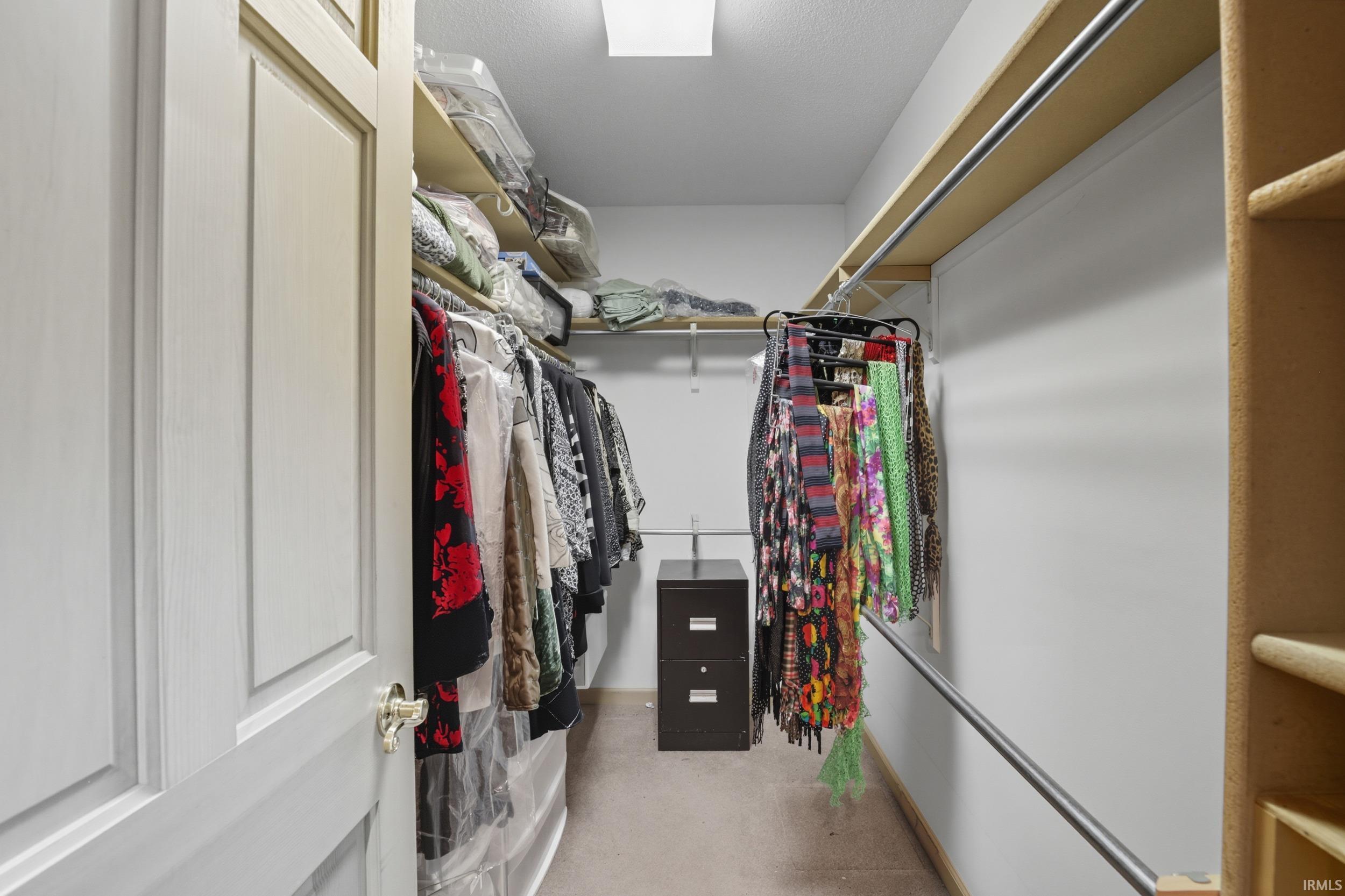 Walk-in closet featuring extensive shelving, multiple hanging rods, and recessed ceiling lighting