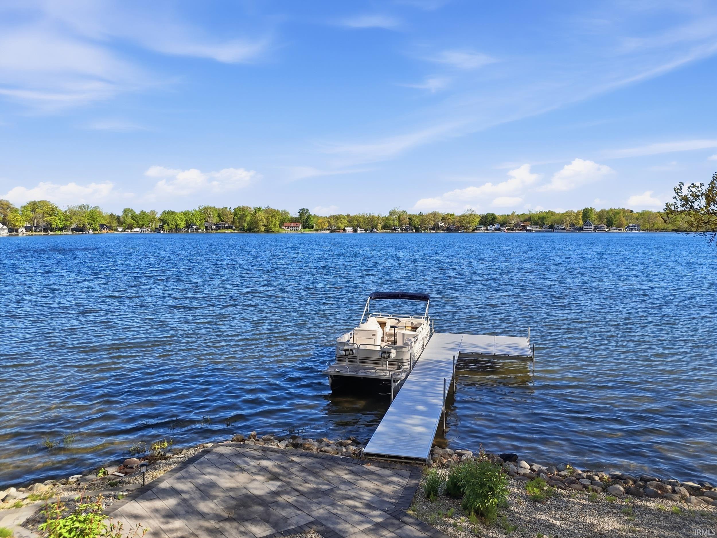 Waterfront property featuring a private dock, direct lake access, and a stone-lined shore