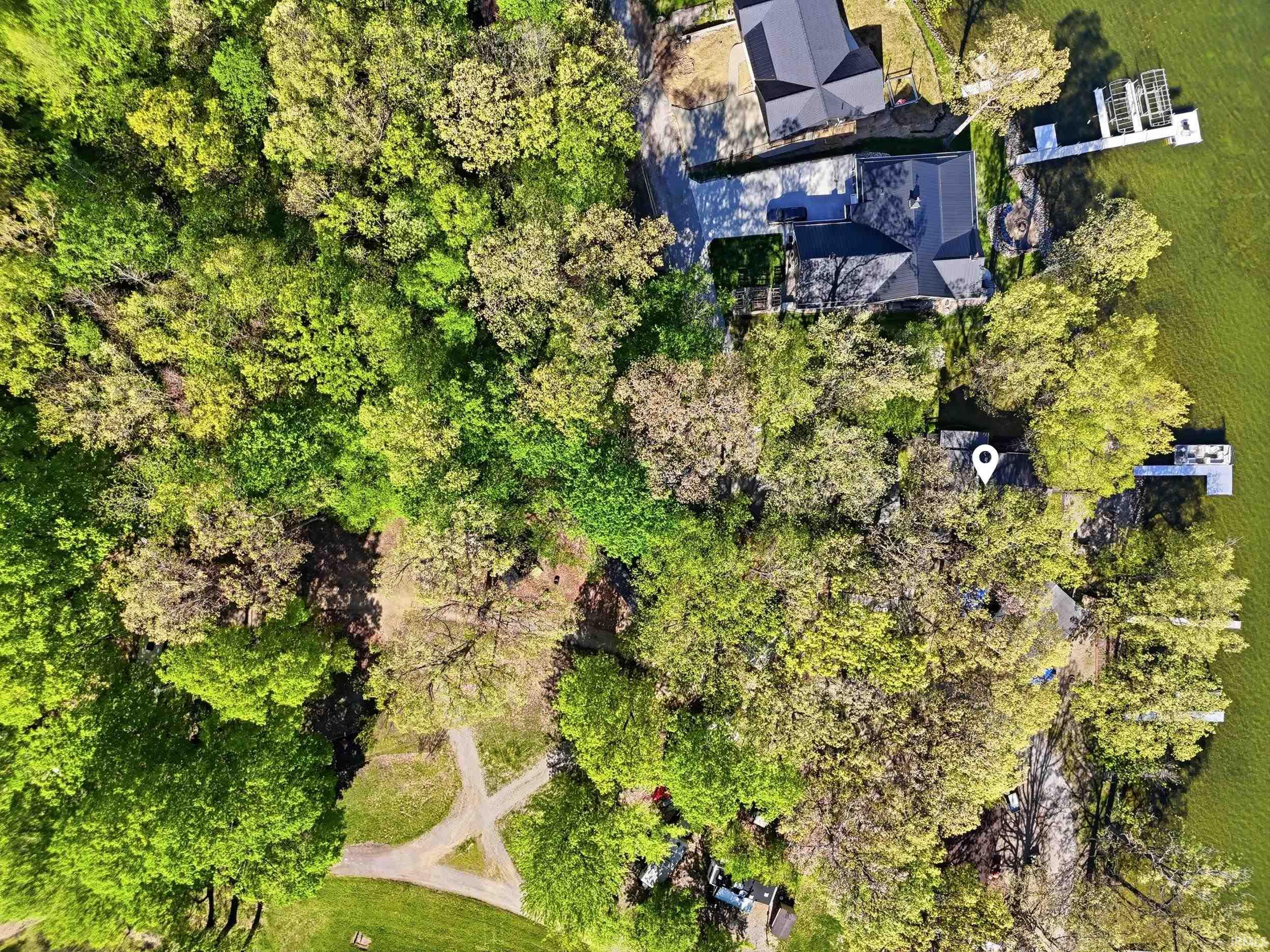 Aerial depiction of a waterfront property with extensive tree coverage