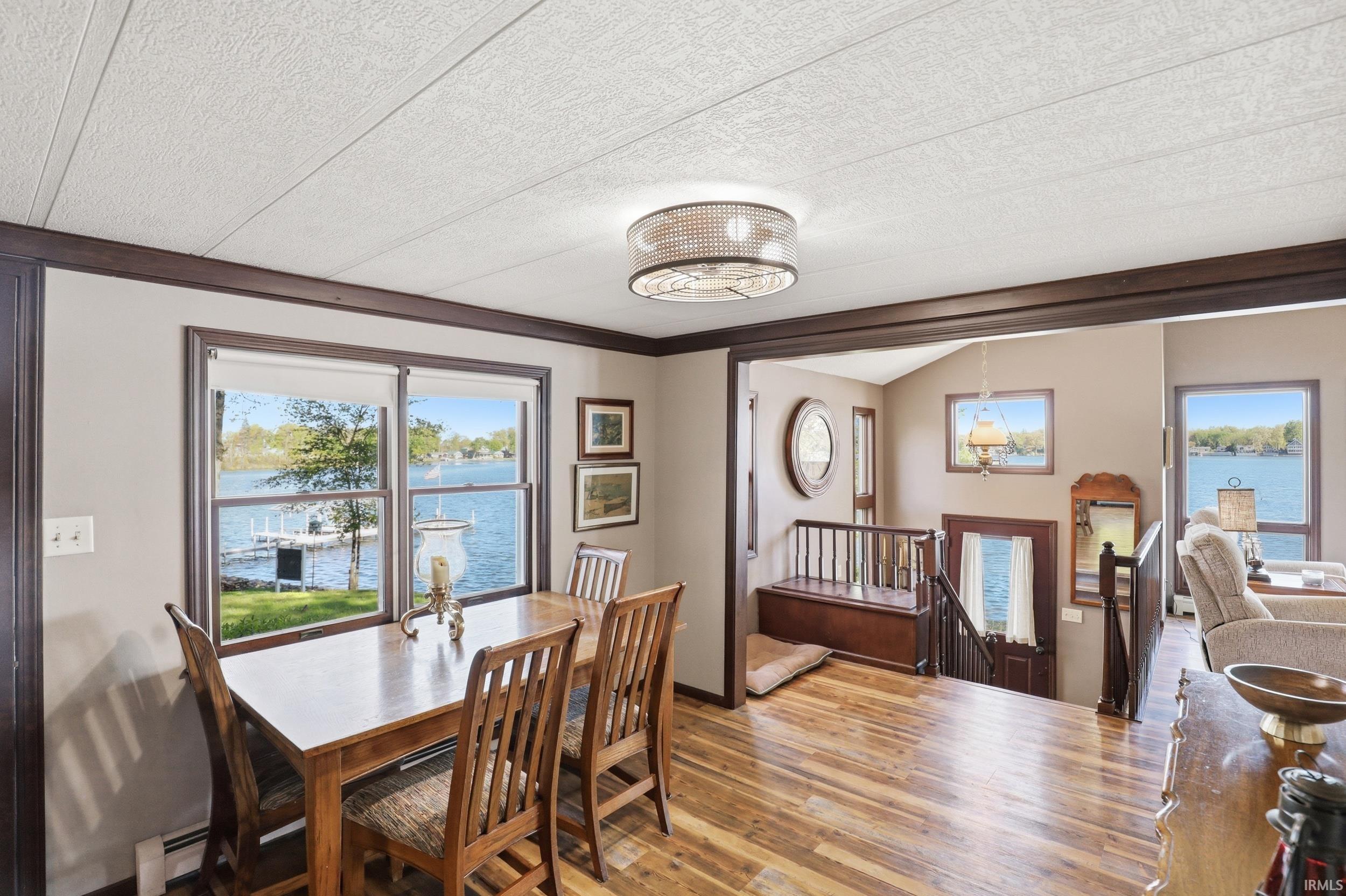 Dining space with wood-finish flooring and a contemporary drum light fixture