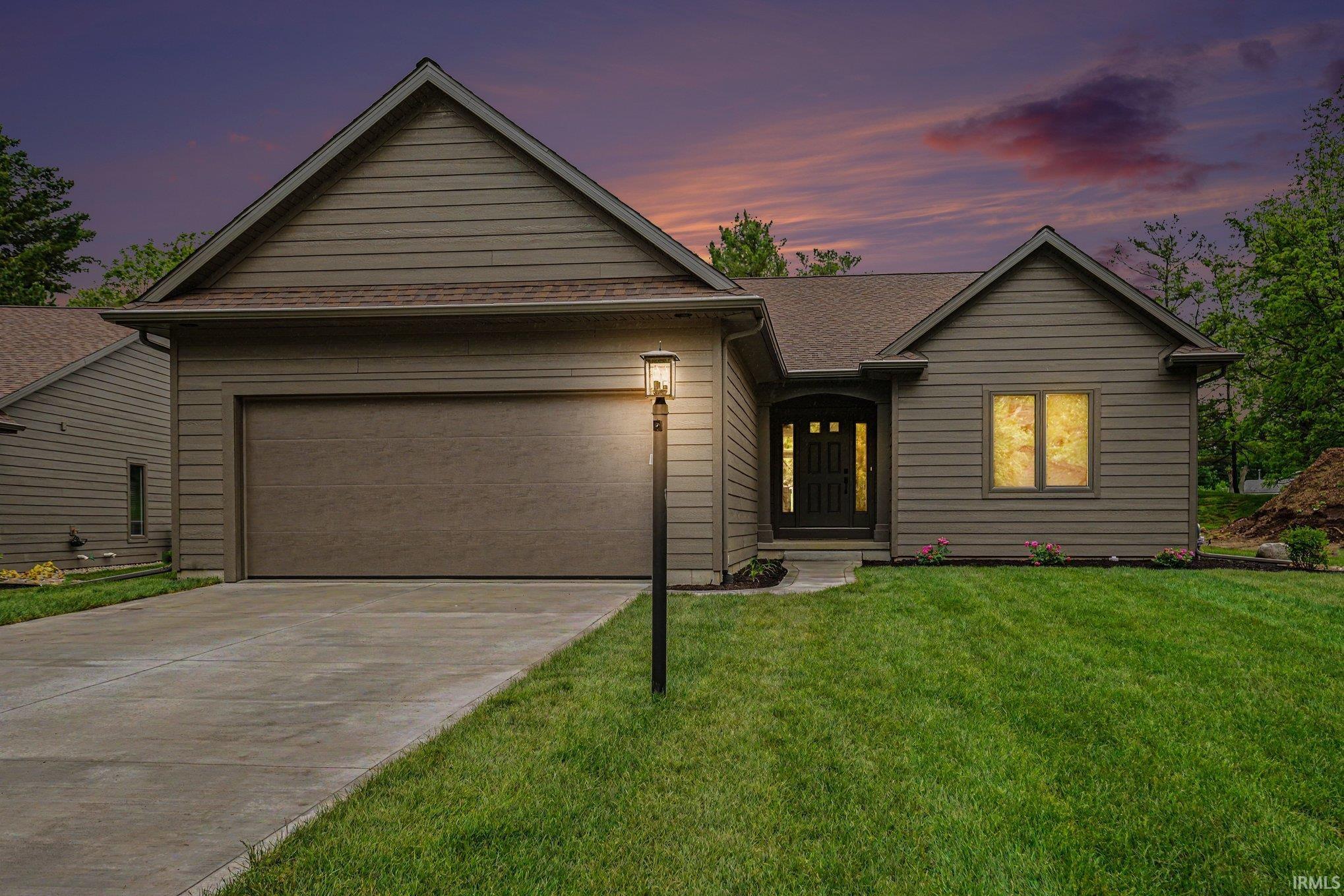 Residential exterior featuring horizontal siding, a two-car garage, and a concrete driveway