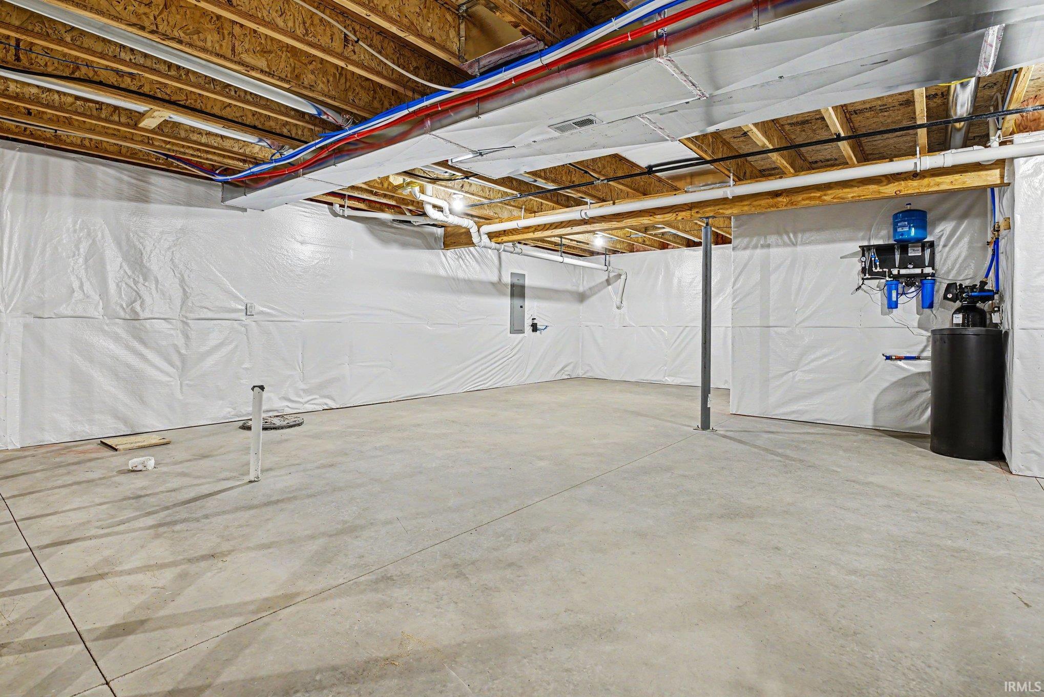 Unfinished basement with concrete flooring and exposed ceiling joists