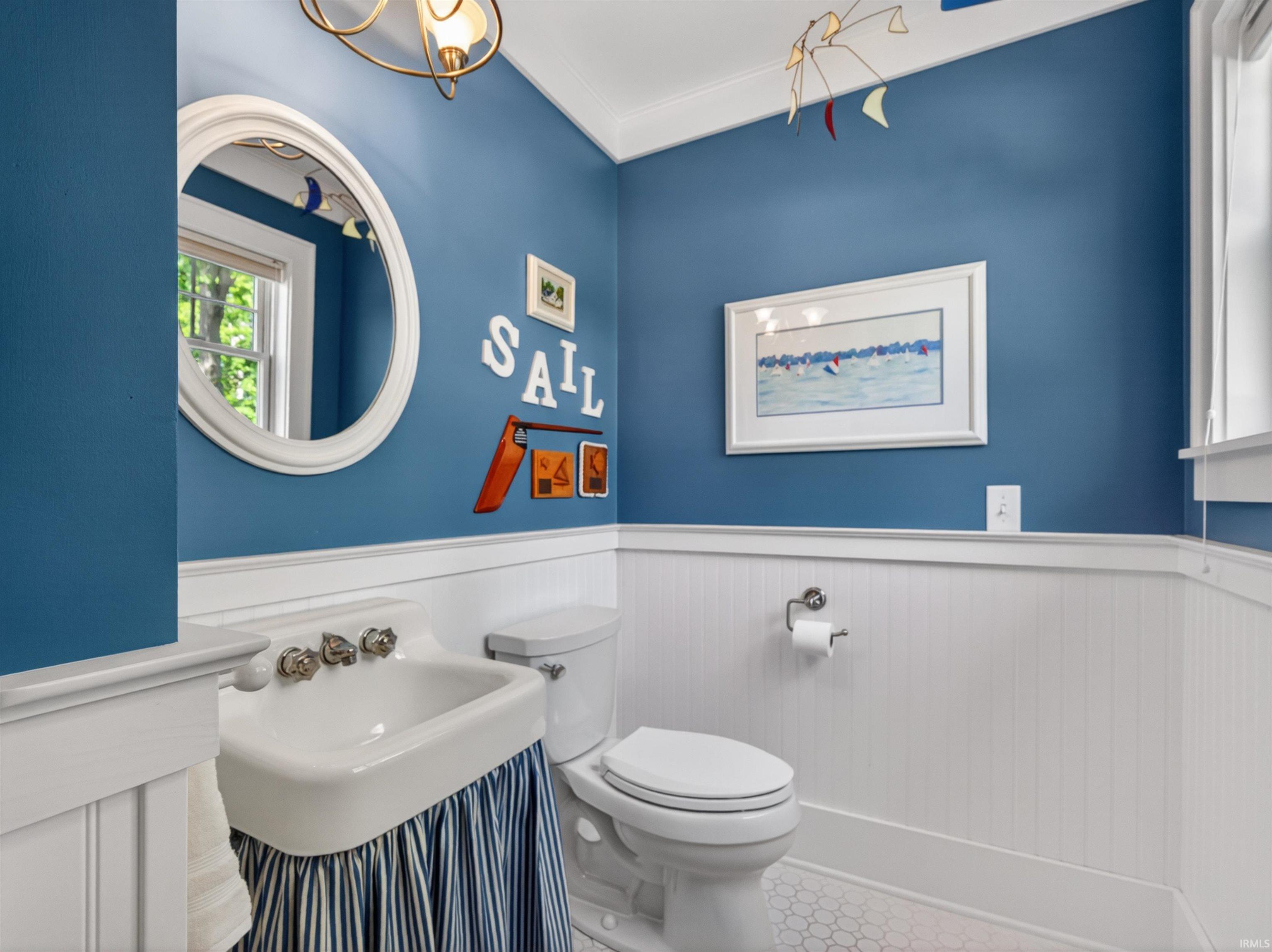 Bathroom featuring a pedestal sink, toilet, and hexagonal floor tiles