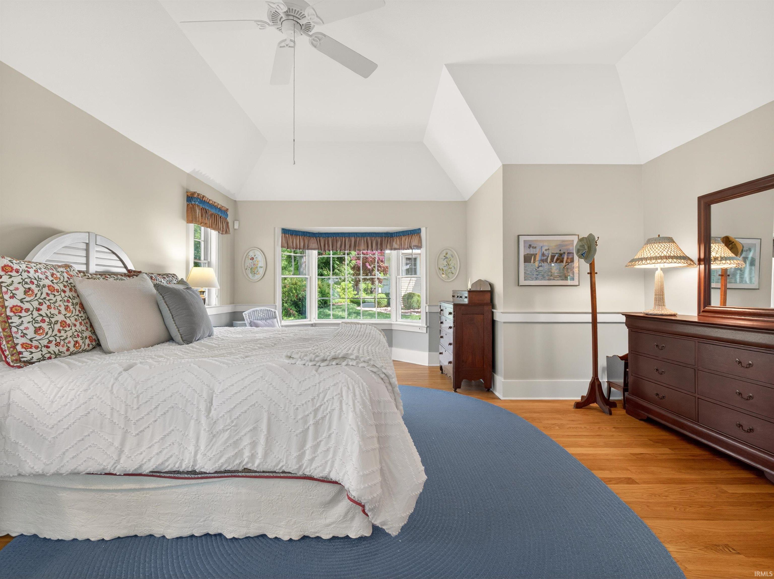 Vaulted ceiling room featuring hardwood flooring
