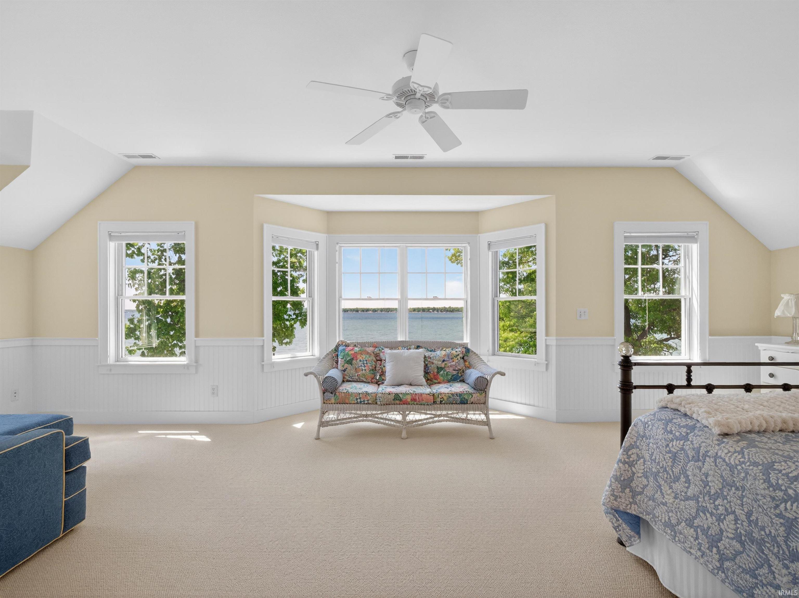 Spacious room featuring a multi-window bay with water scenery, complemented by additional windows providing natural light