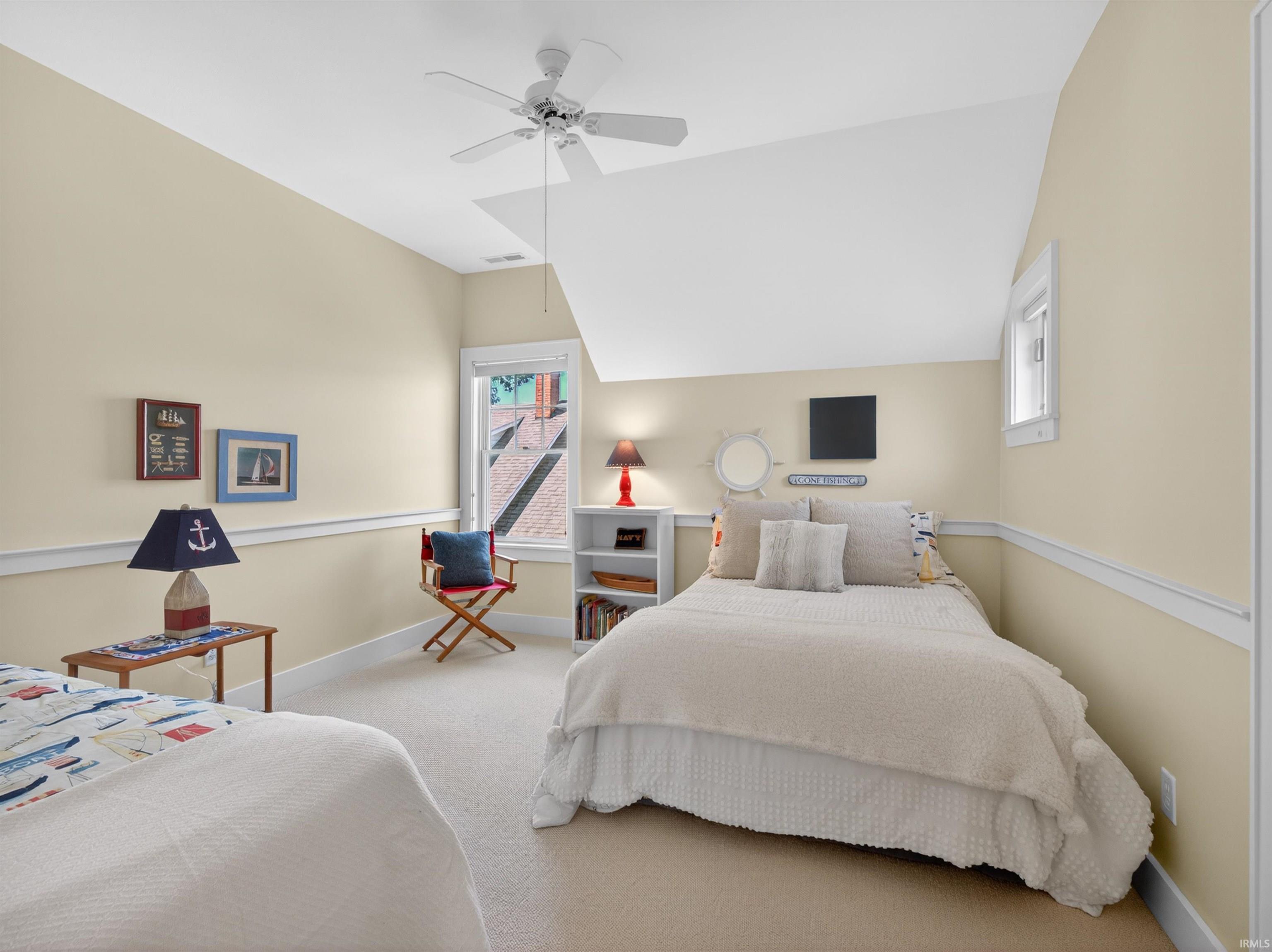 Carpeted room with a ceiling fan, light-toned walls, and white trim