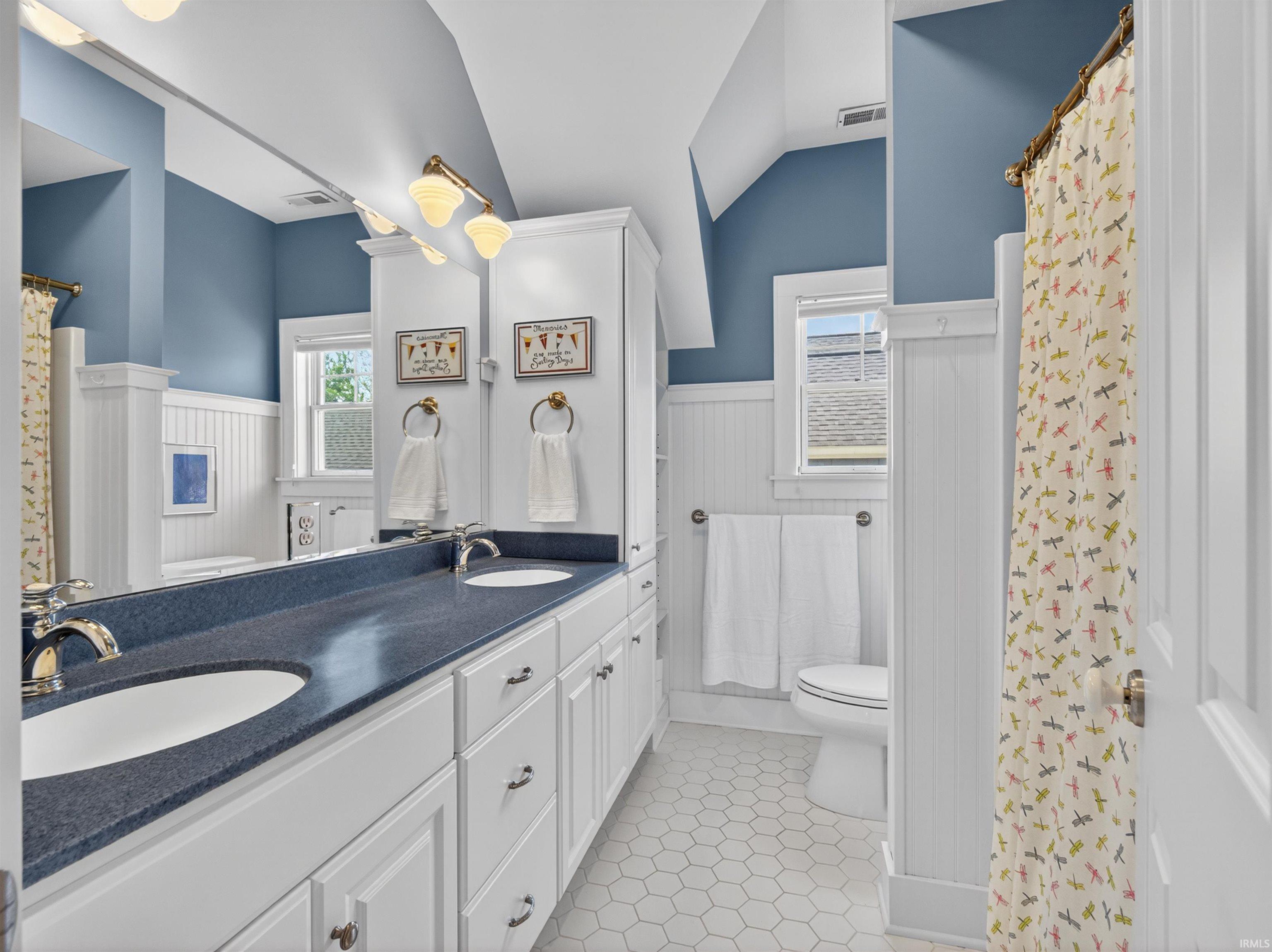 Double vanity featuring integrated sinks and a dark-toned countertop
