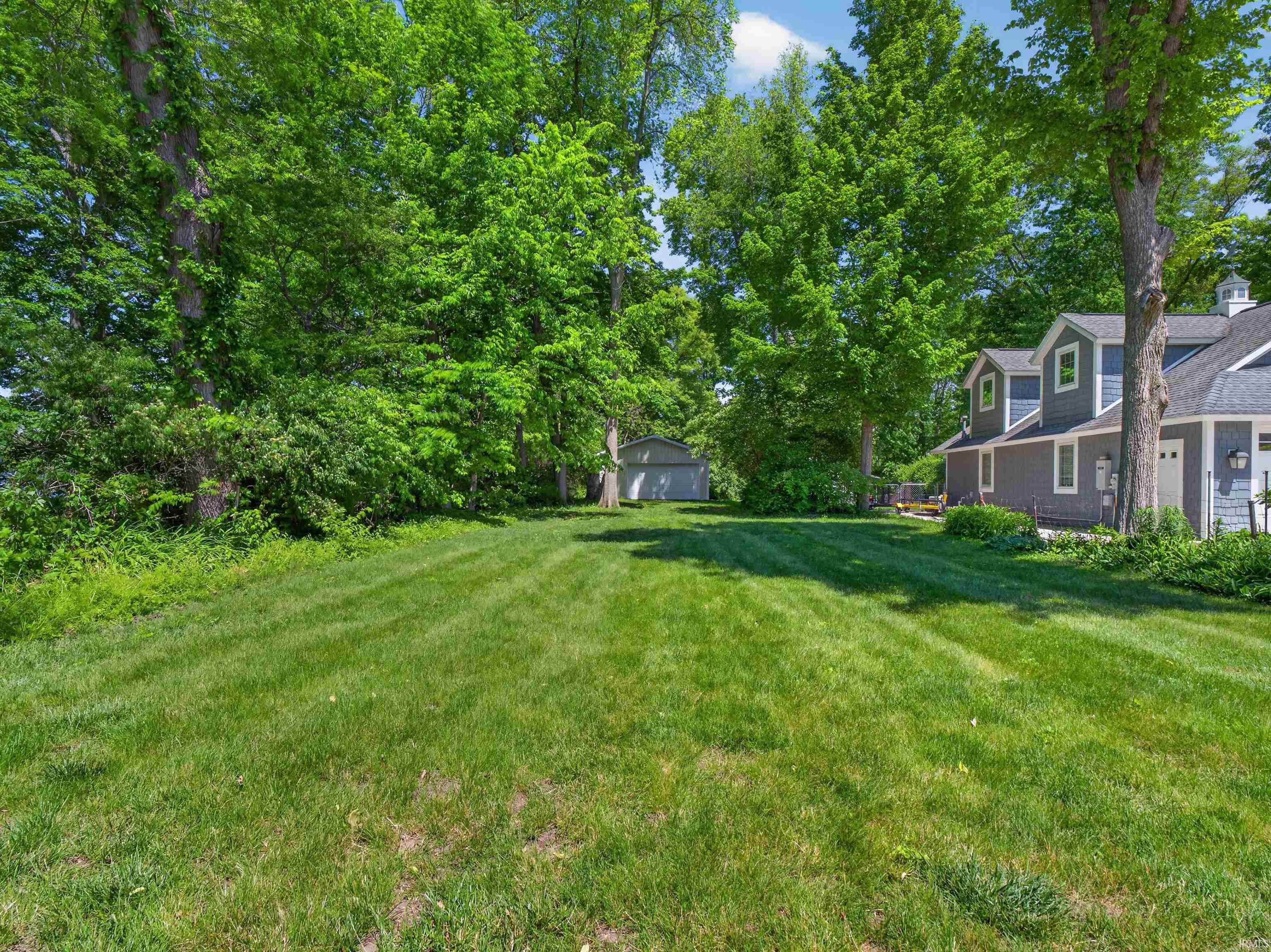 Expansive green lawn framed by mature trees