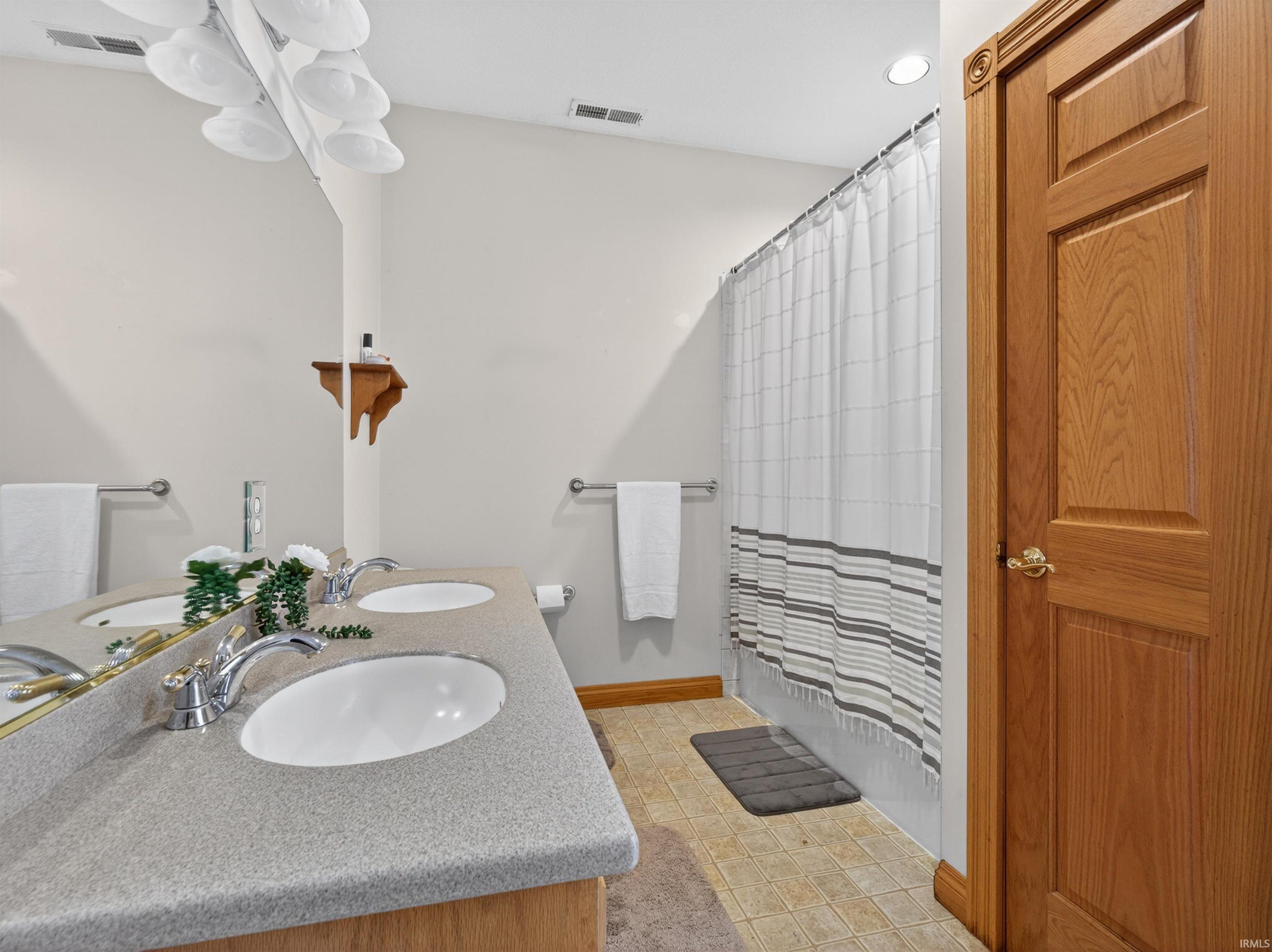 Bathroom featuring a double vanity with integrated sinks and chrome fixtures