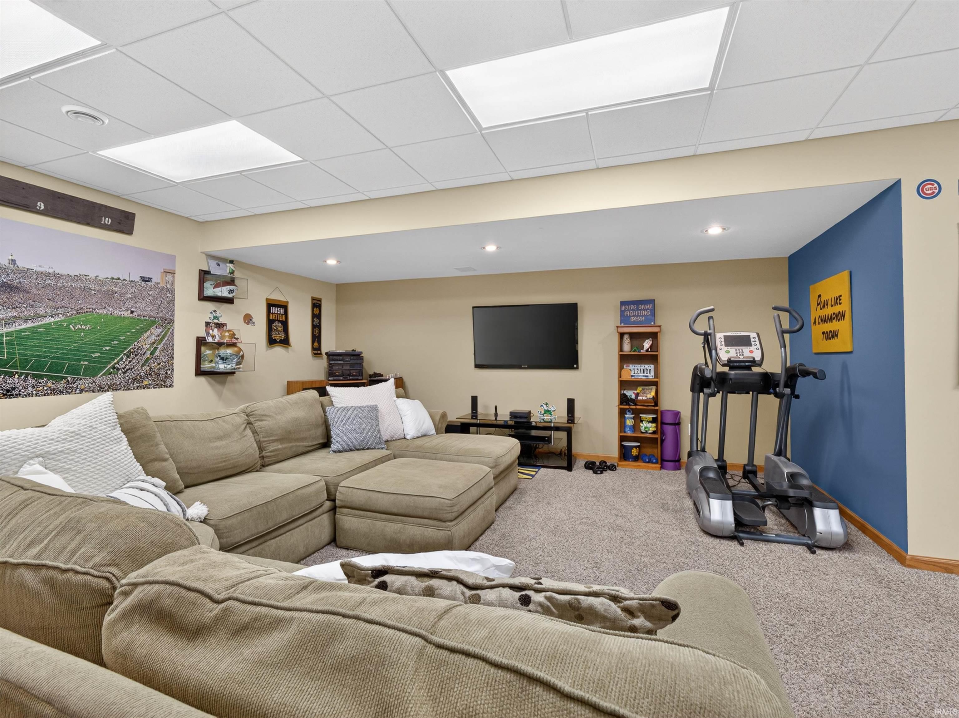 Spacious finished basement with drop ceiling, recessed lighting, and soft carpet flooring