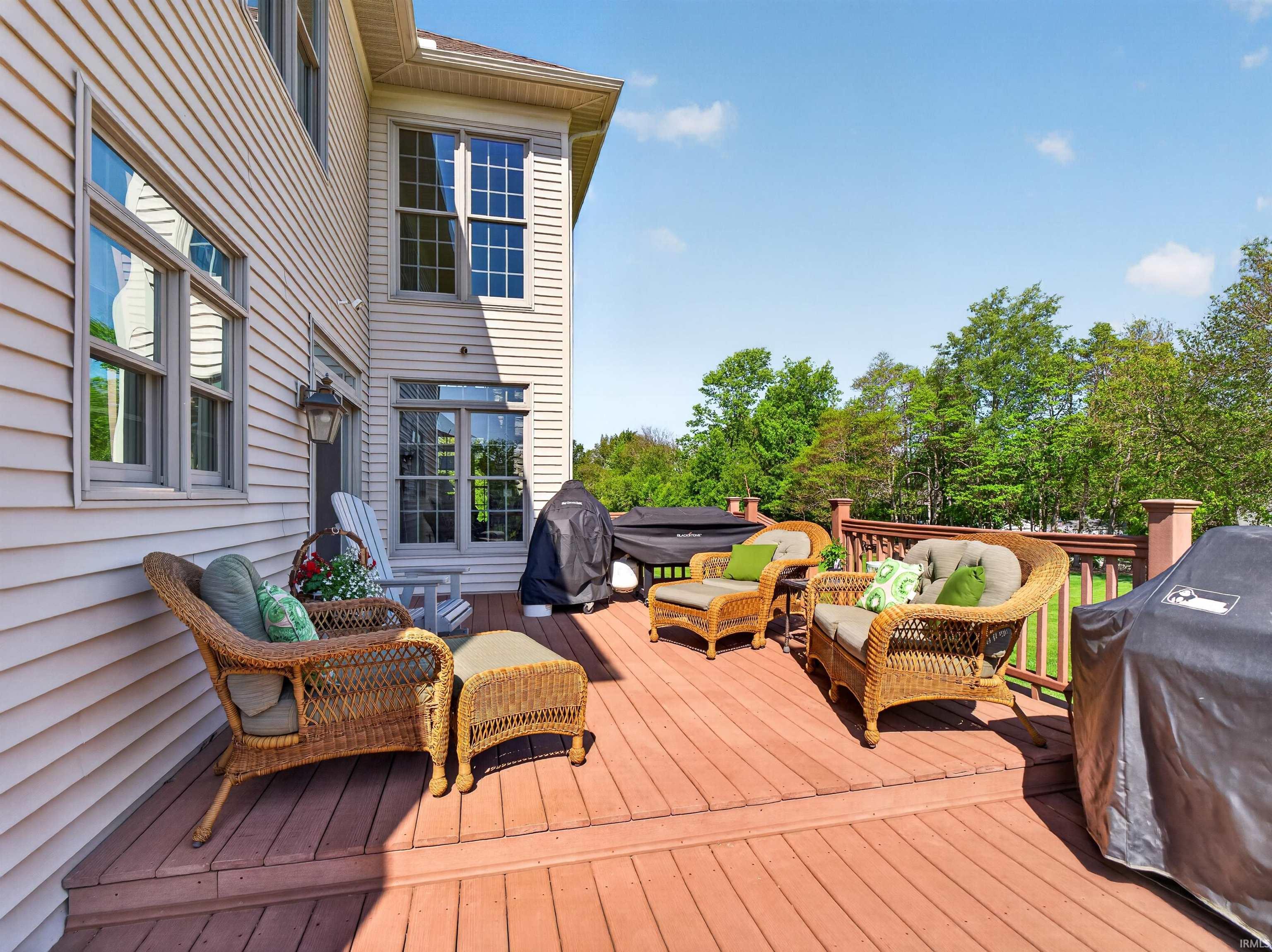 Multi-level wood deck featuring a railing system and access to the interior