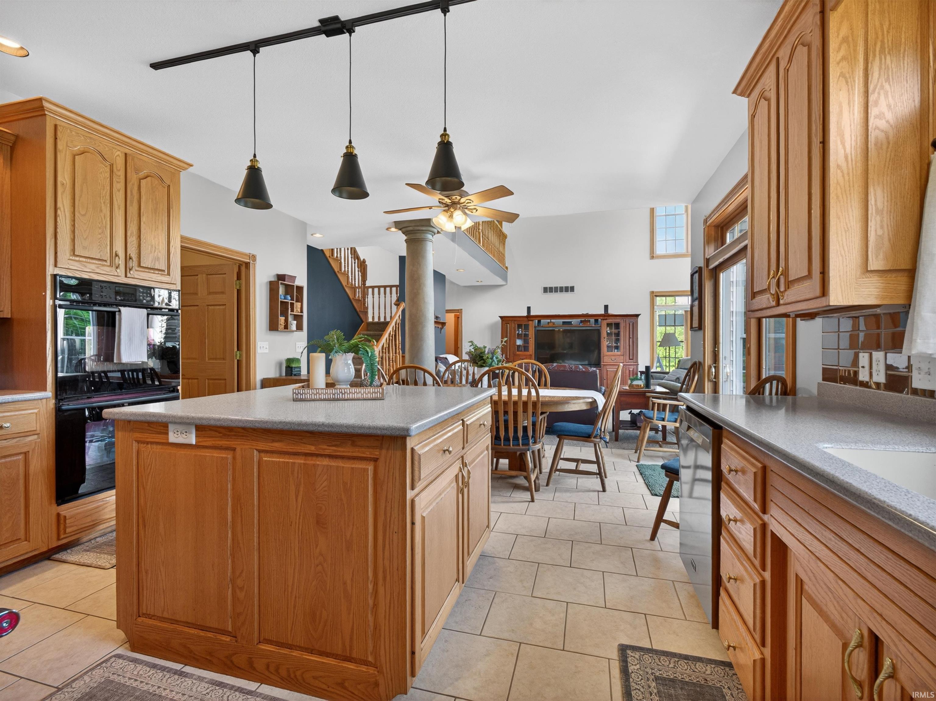 Kitchen featuring a central island with a light-toned countertop, wood-finish cabinetry, and ceramic tile flooring