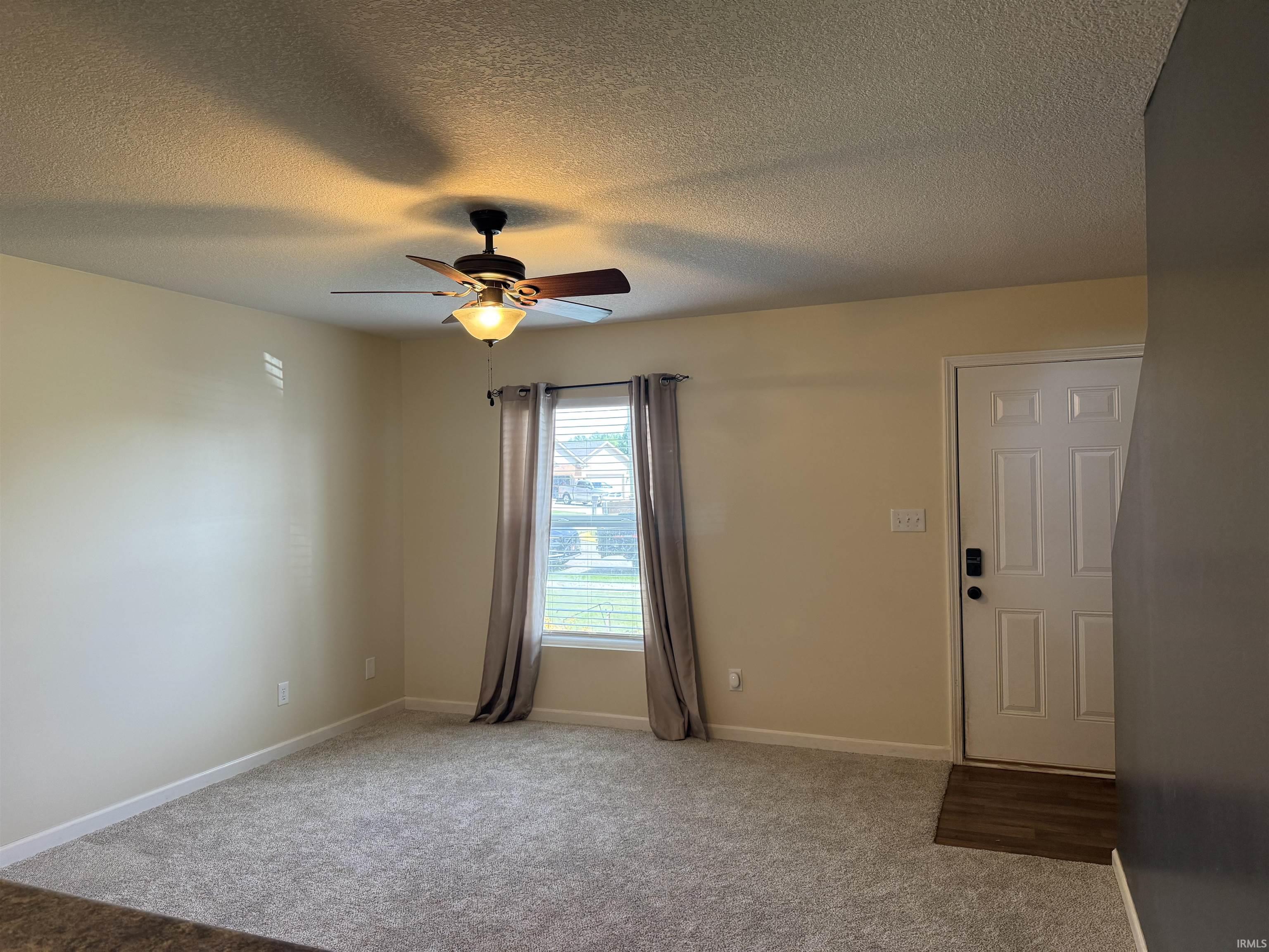 Spacious room featuring neutral carpeting and light-toned walls