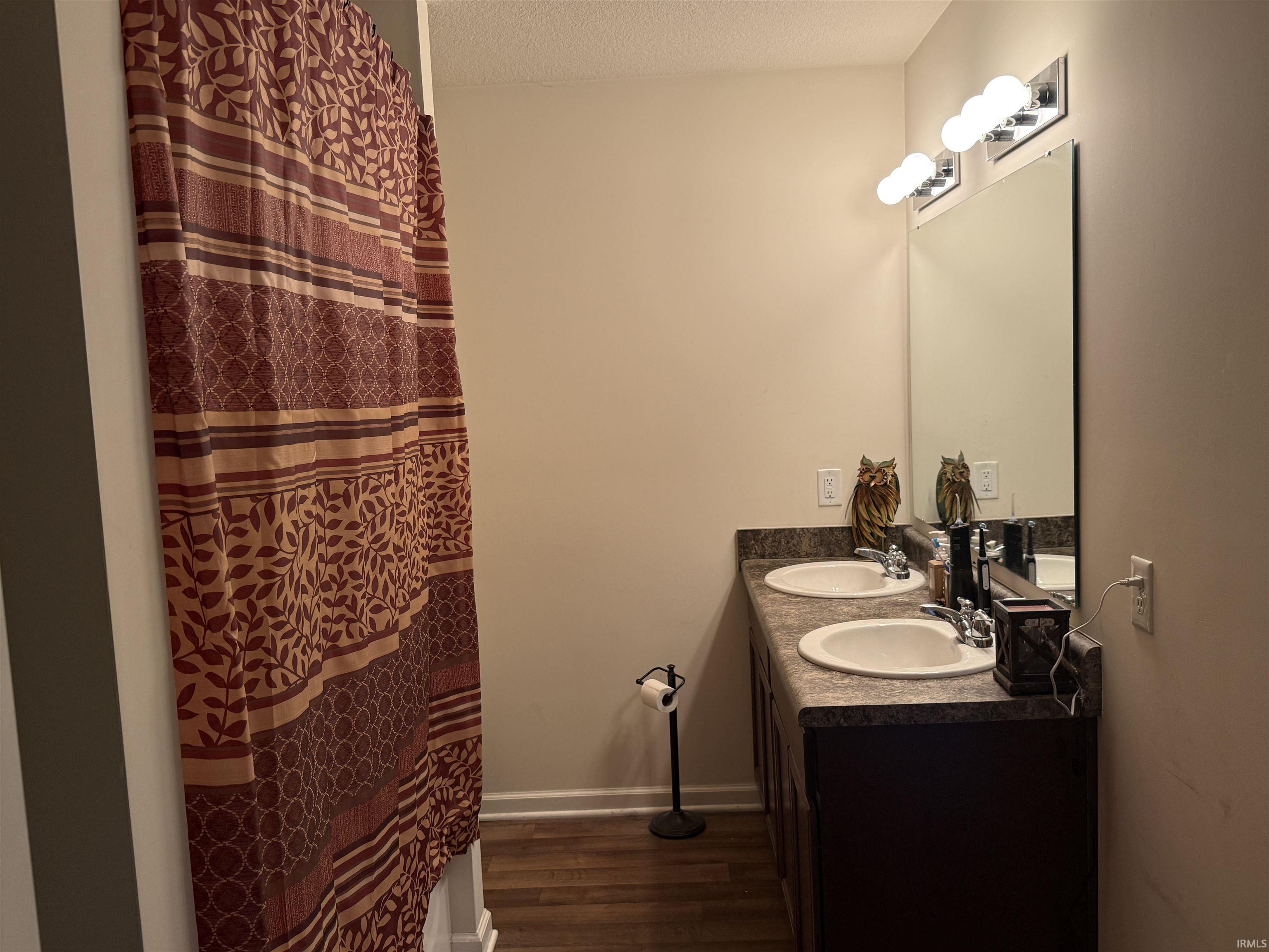 Bathroom vanity with dual undermount sinks and dark wood-finish cabinetry