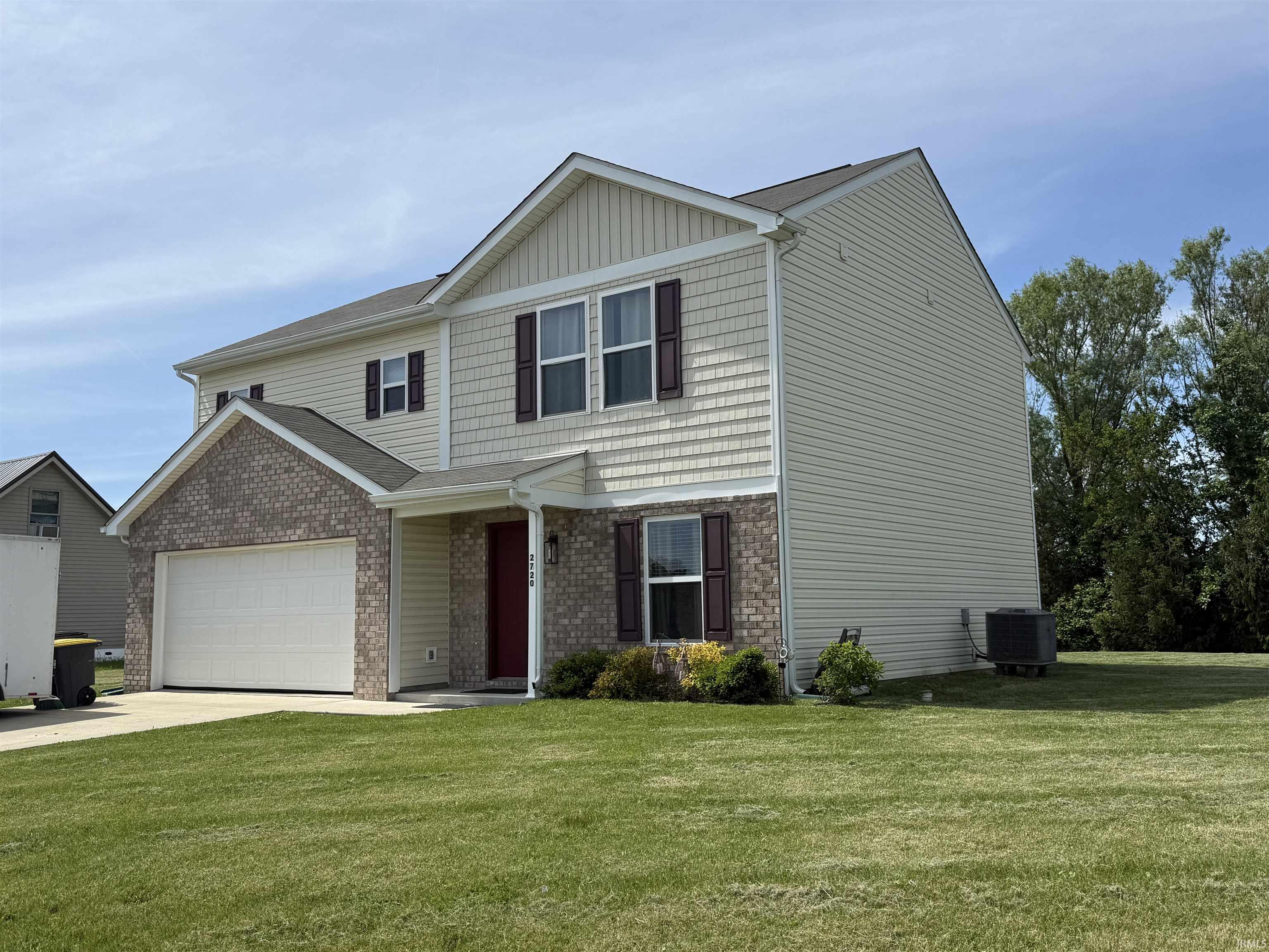 Two-story residence featuring a combination of light-colored siding, shake siding, and brick facade
