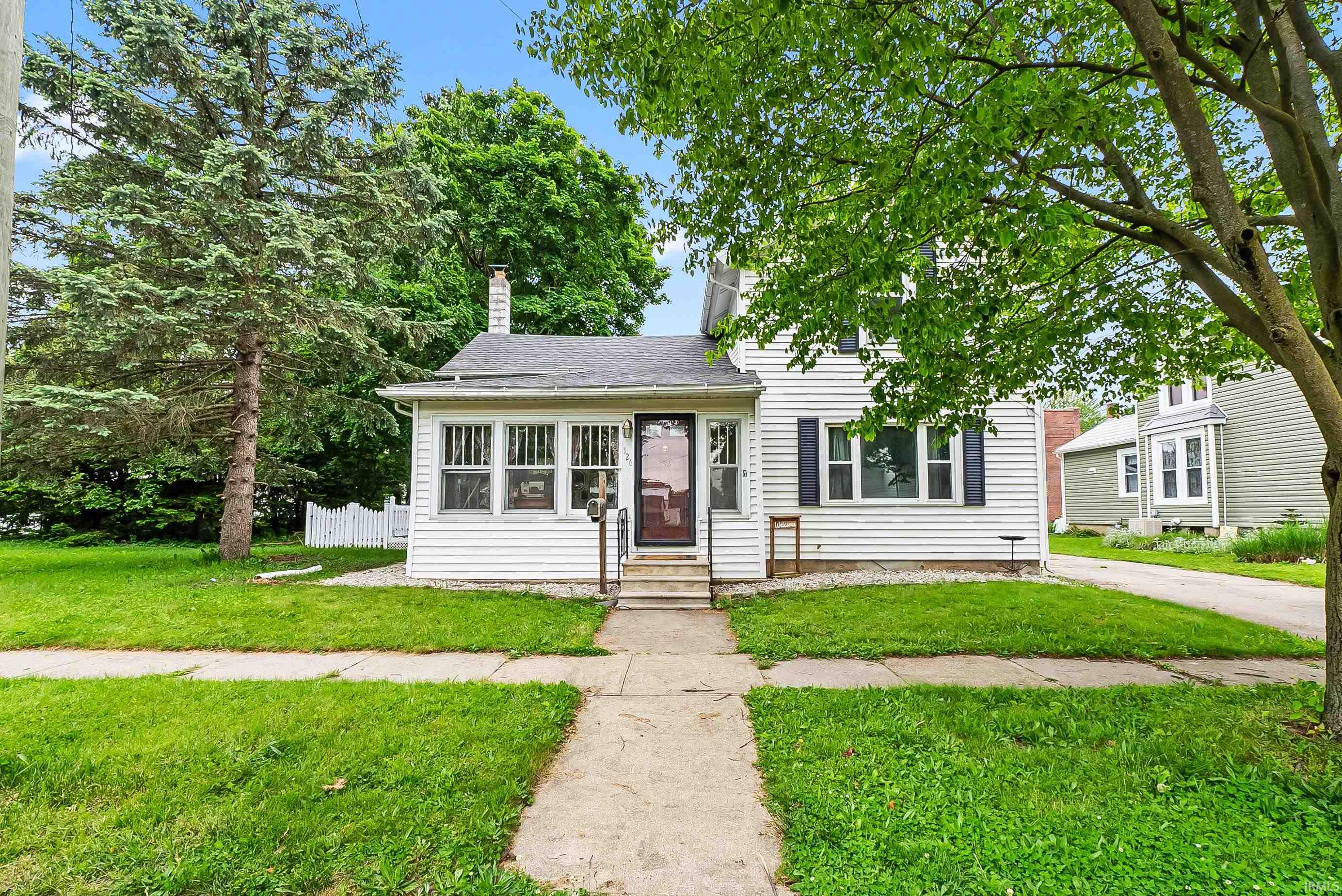 White siding exterior with dark shutters and a covered entry