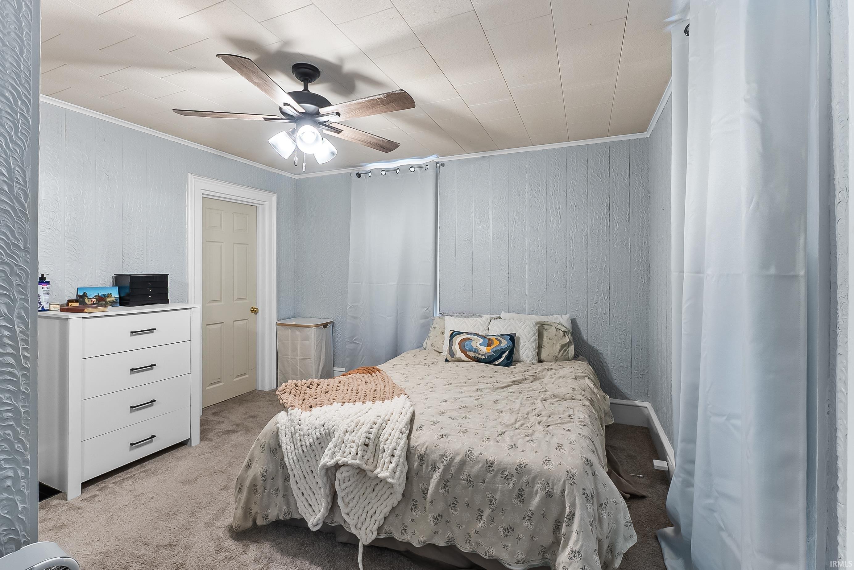 Textured wall paneling and a ceiling fan with integrated lighting
