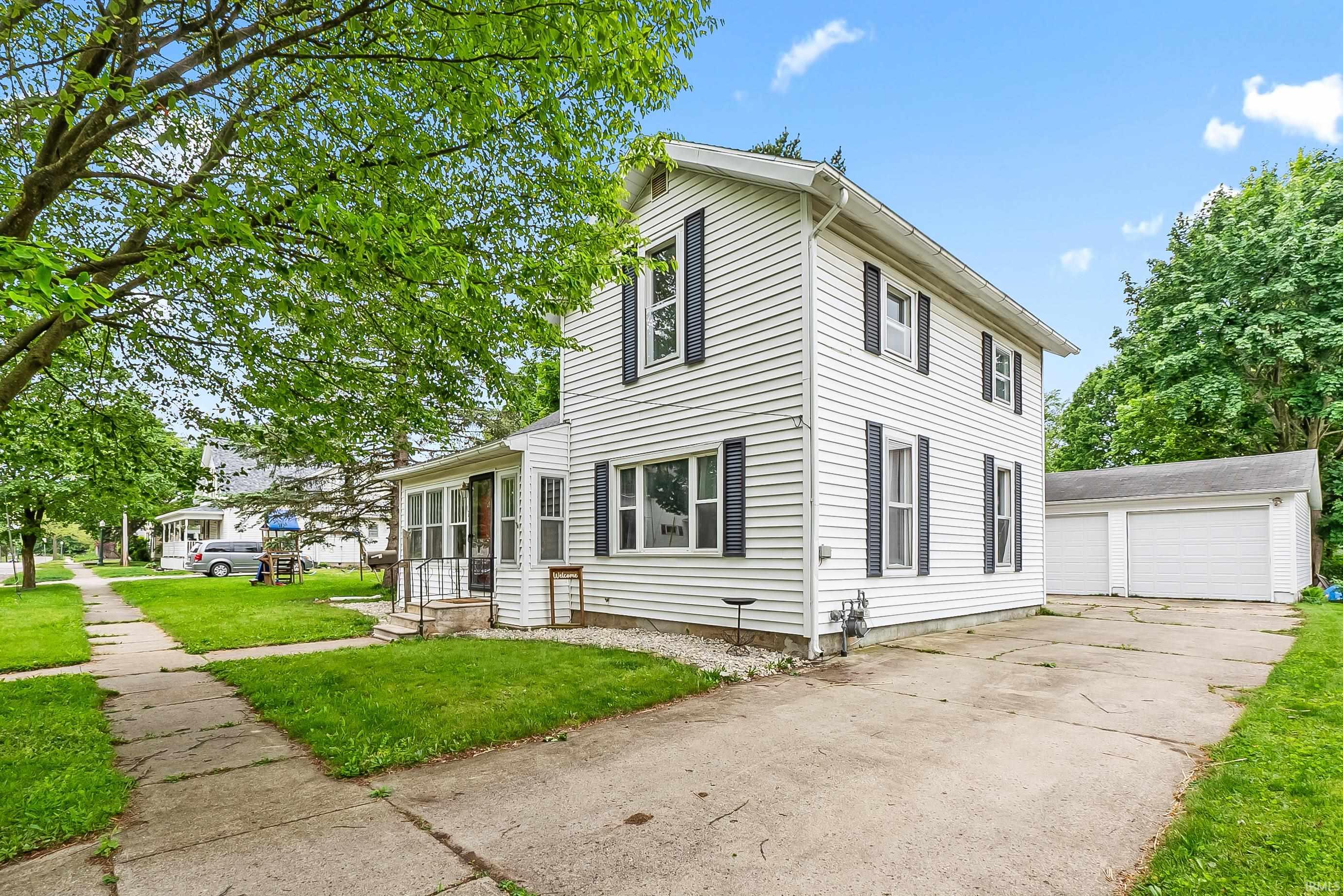 Two-story home featuring white siding and dark shutters