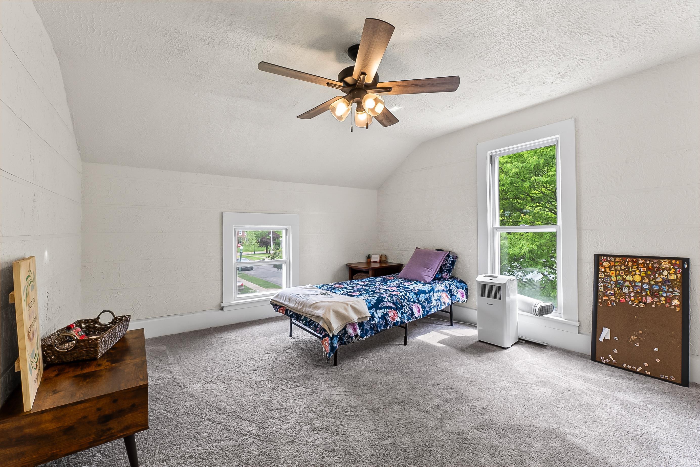 Attic room featuring a sloped ceiling, light gray carpet, and white shiplap-style wall paneling