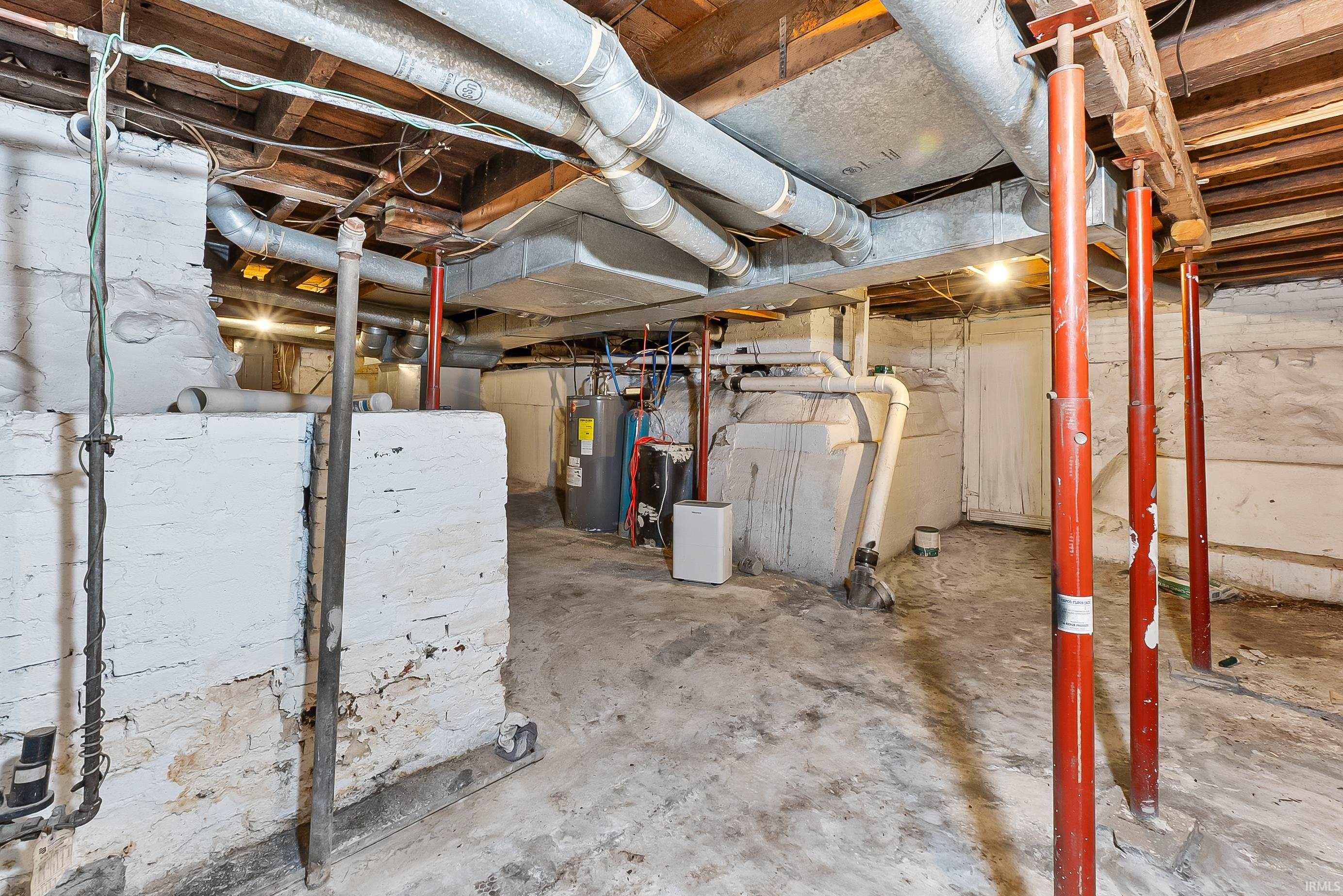 Utility area featuring exposed ductwork, support beams, and a water heater