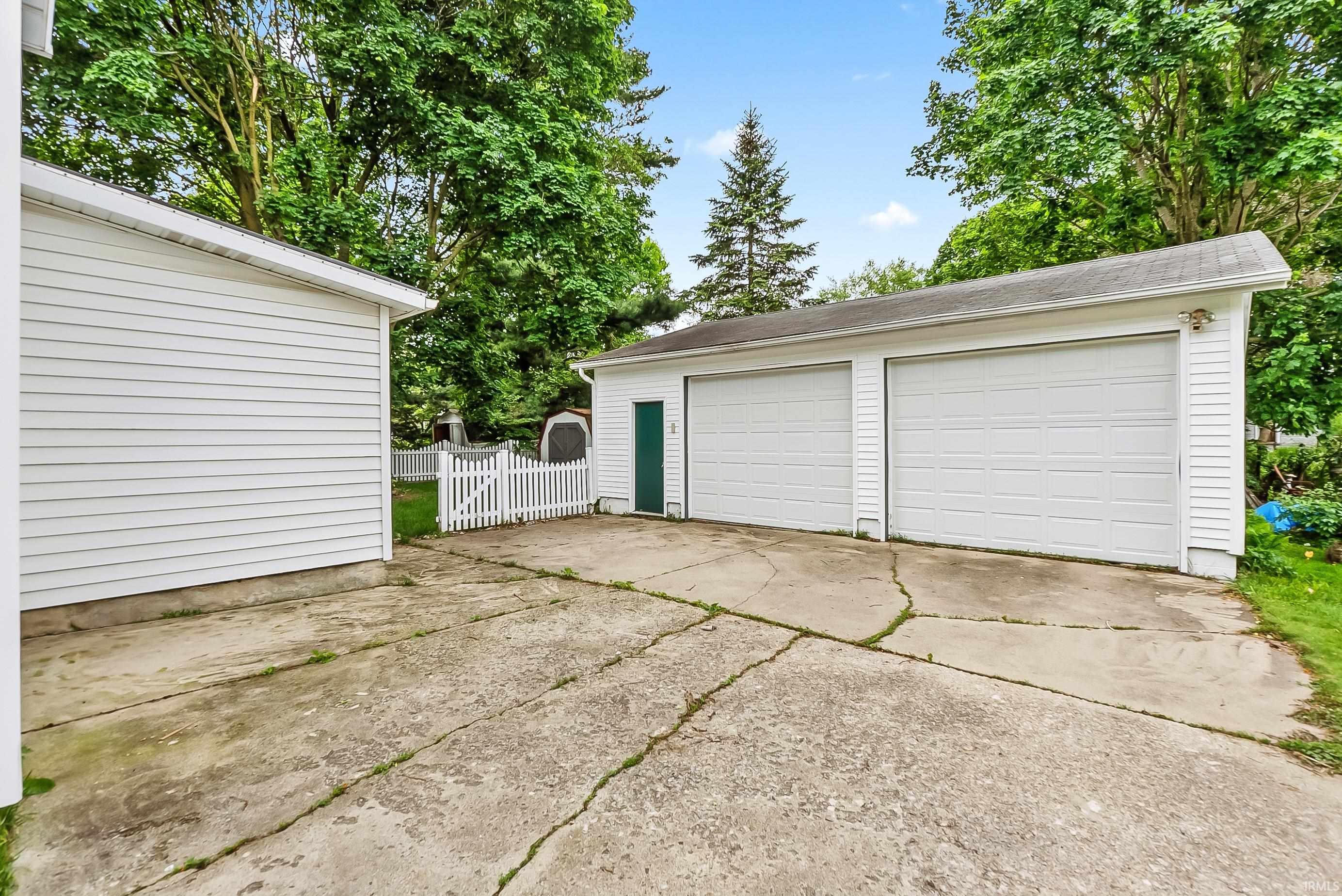 Detached two-car garage with white paneled doors and an additional side access door