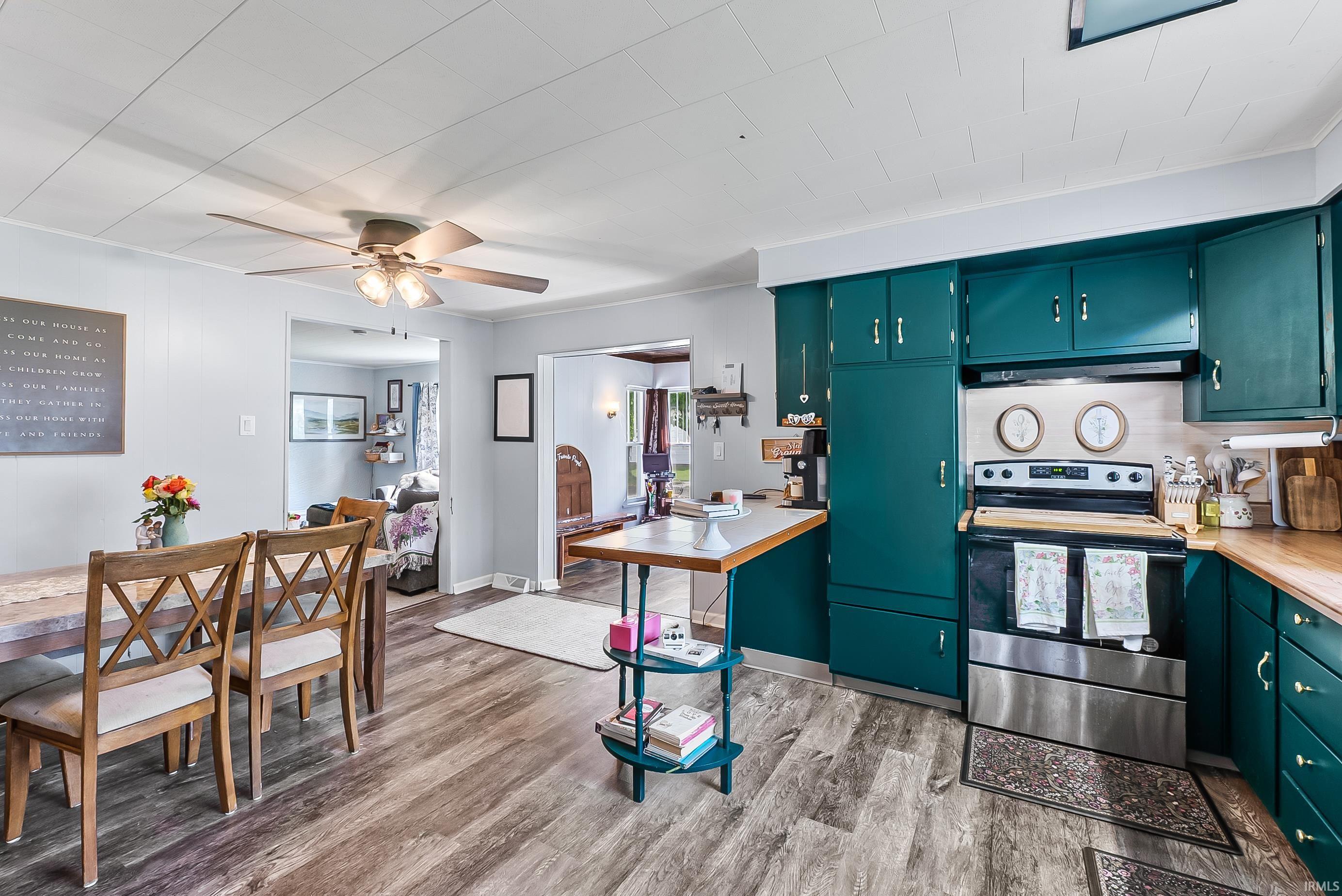 Kitchen featuring teal cabinetry, wood-finish flooring, and light countertops
