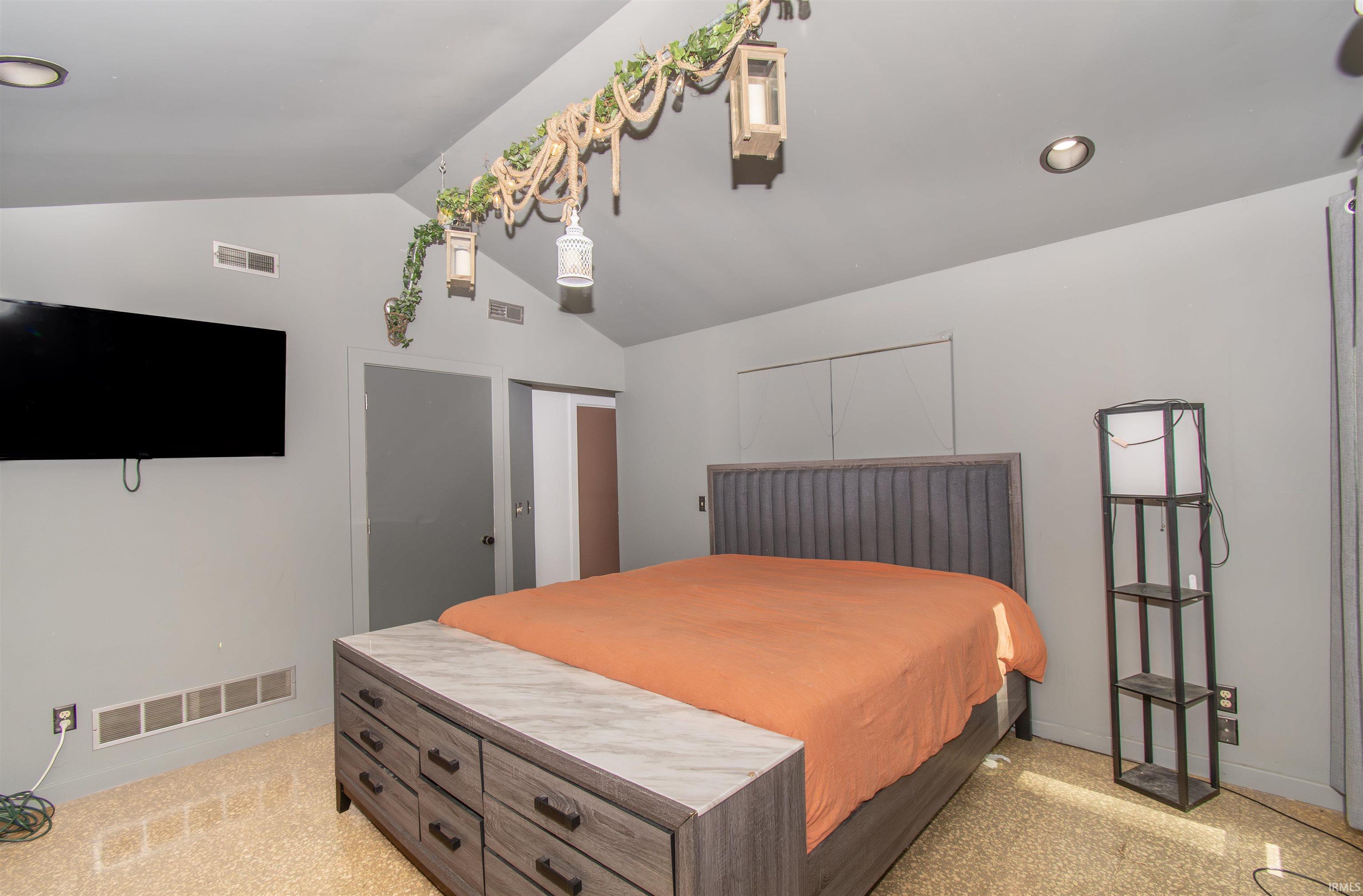Vaulted ceiling room with recessed lighting, light-colored walls, built-in air vents, and wood-finish flooring