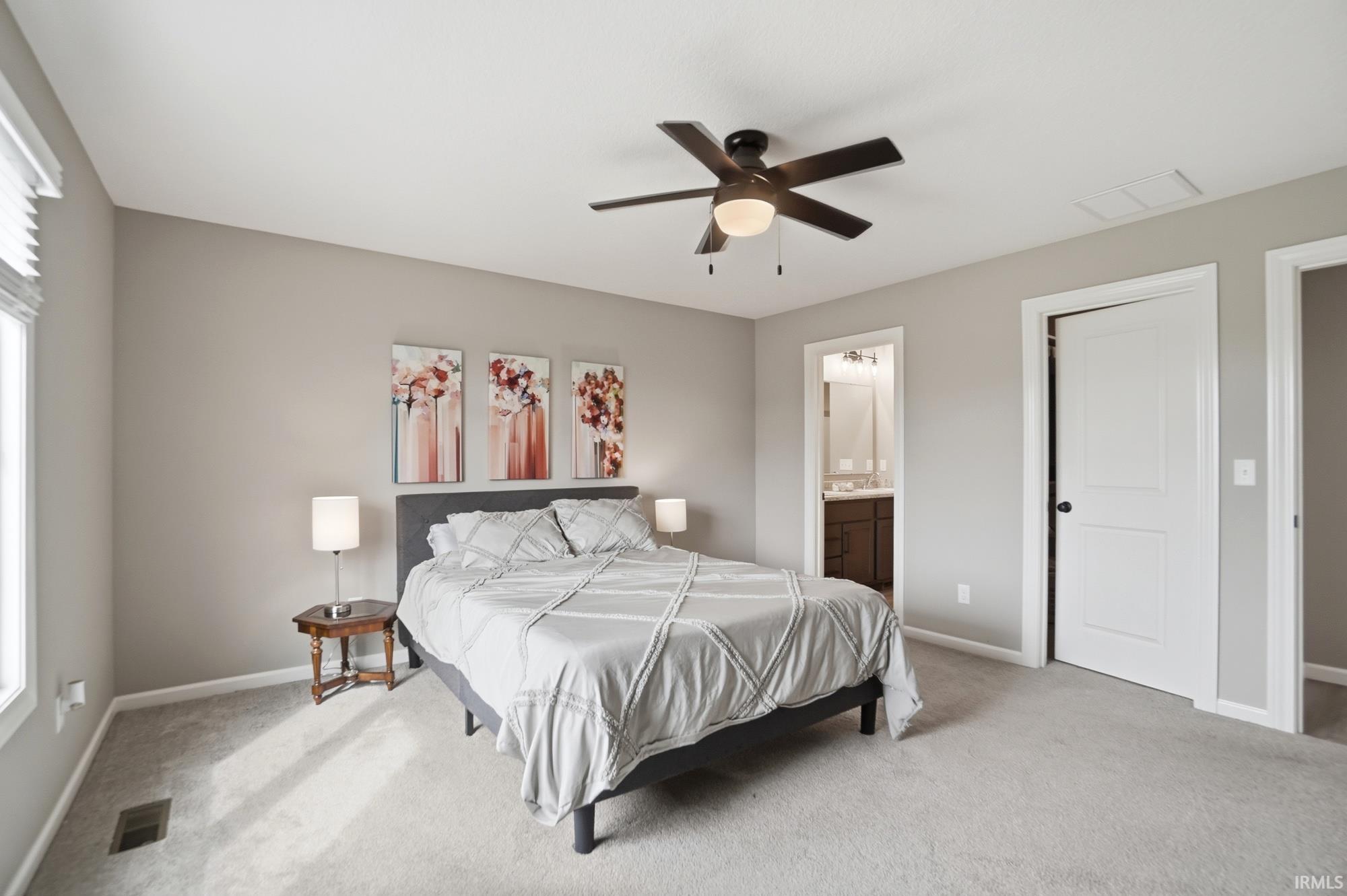 Carpeted bedroom featuring a ceiling fan with integrated lighting, a window with blinds, and neutral wall tones