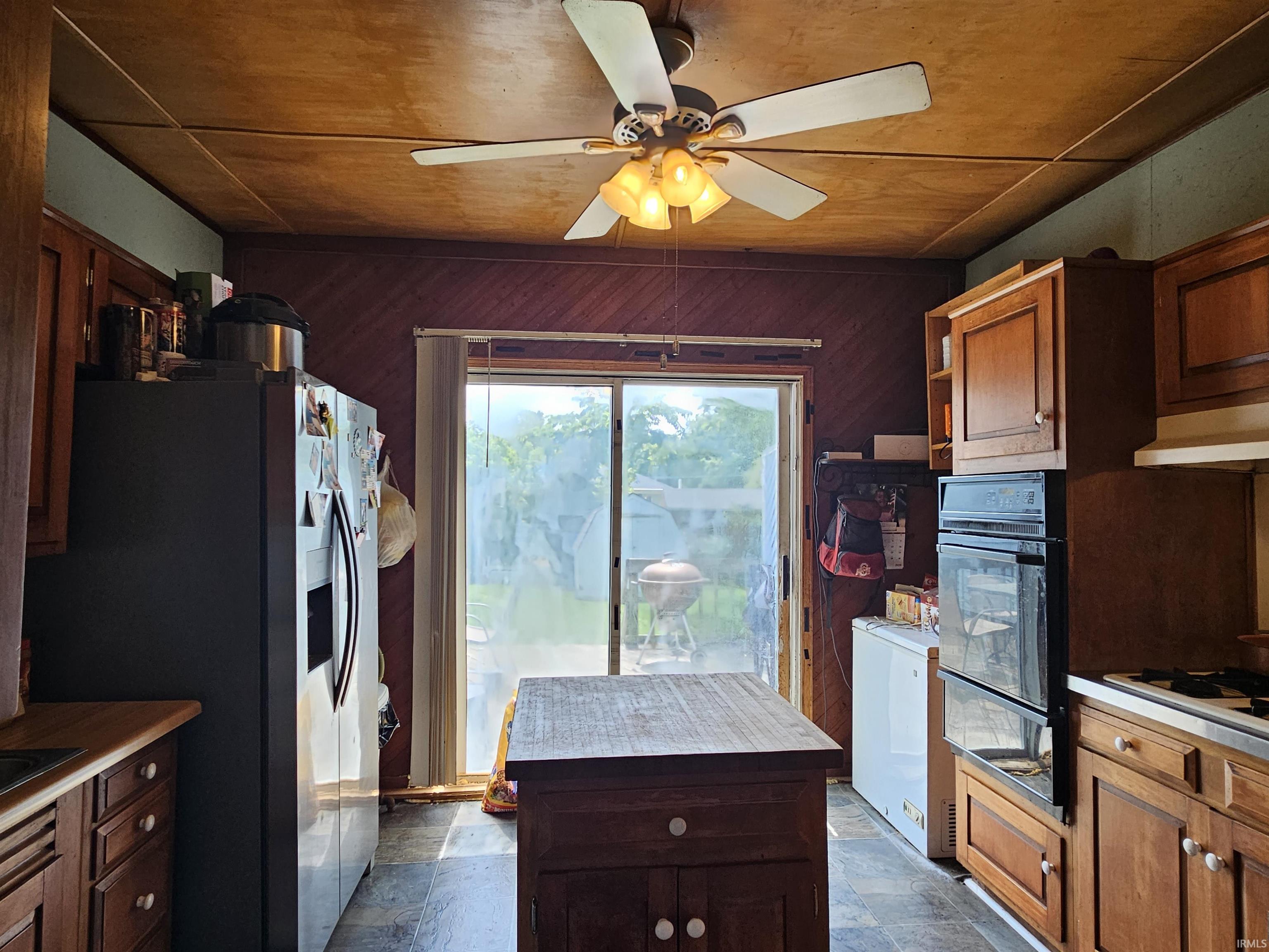 Kitchen featuring wood-finish cabinetry, built-in double oven, and sliding glass door access to the outdoors