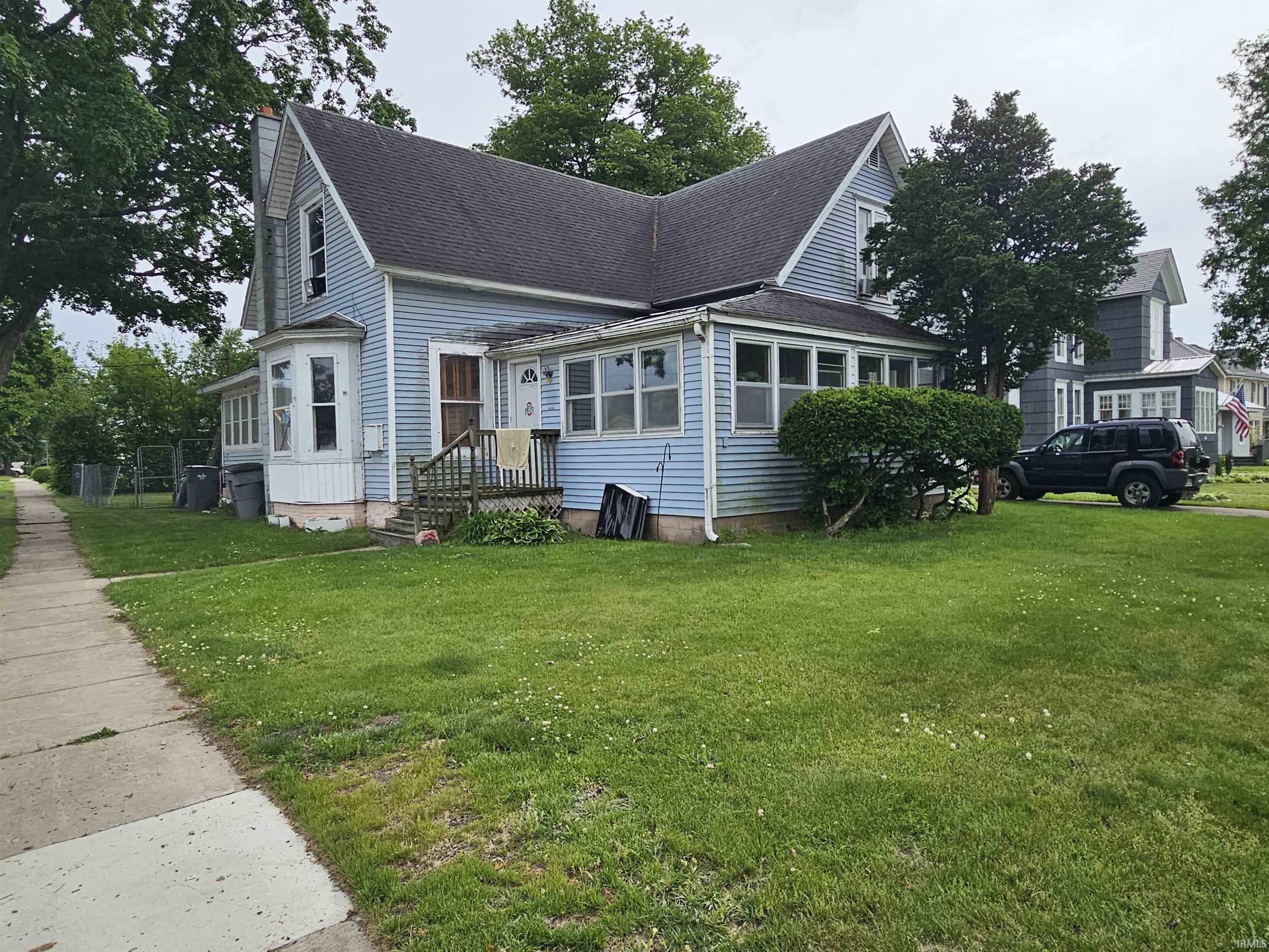Light blue siding exterior featuring multiple gables and a covered front porch