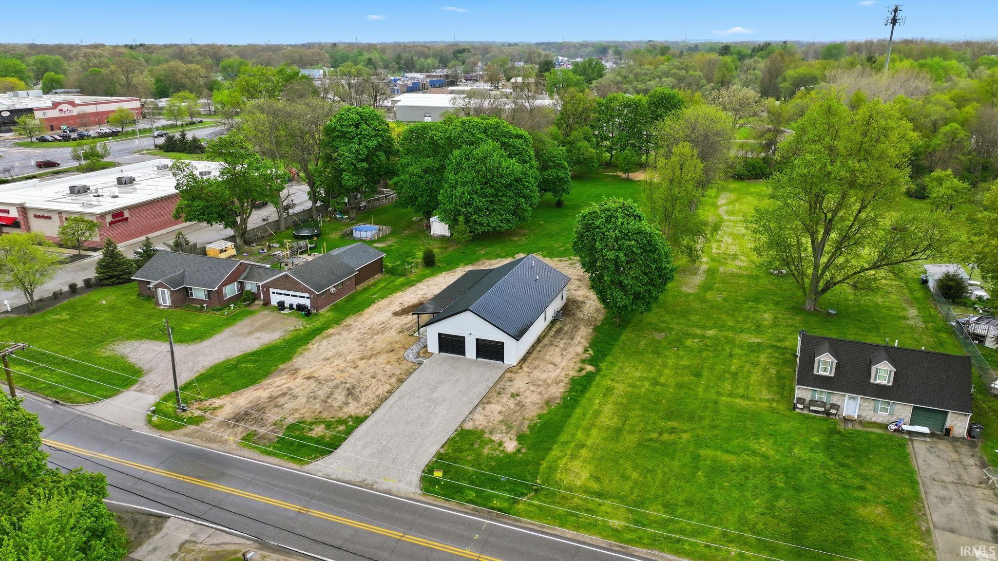 White-sided residence with a black roof and attached two-car garage