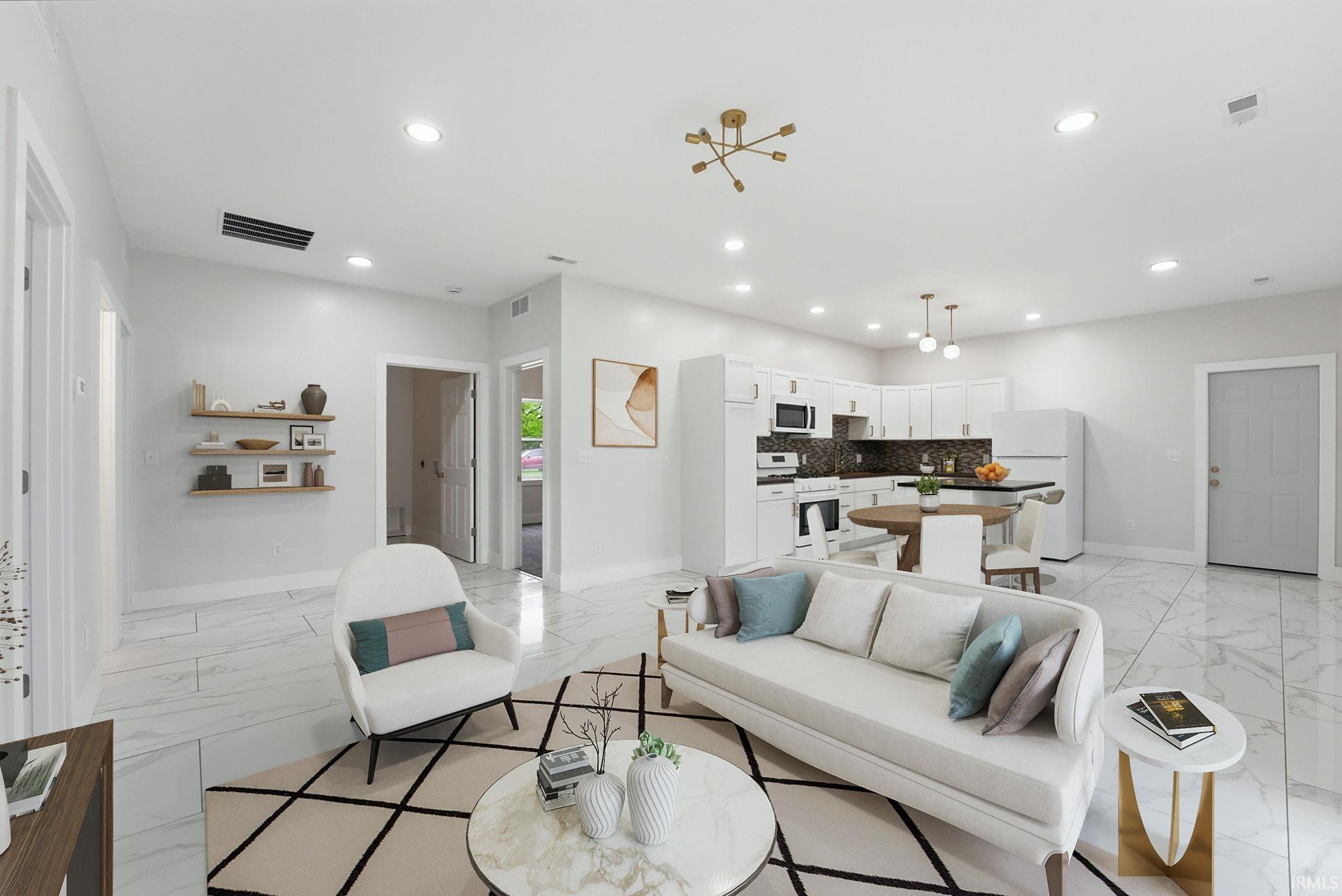 Open-concept living space with recessed lighting, white cabinetry, dark stone countertops, and white tile flooring throughout