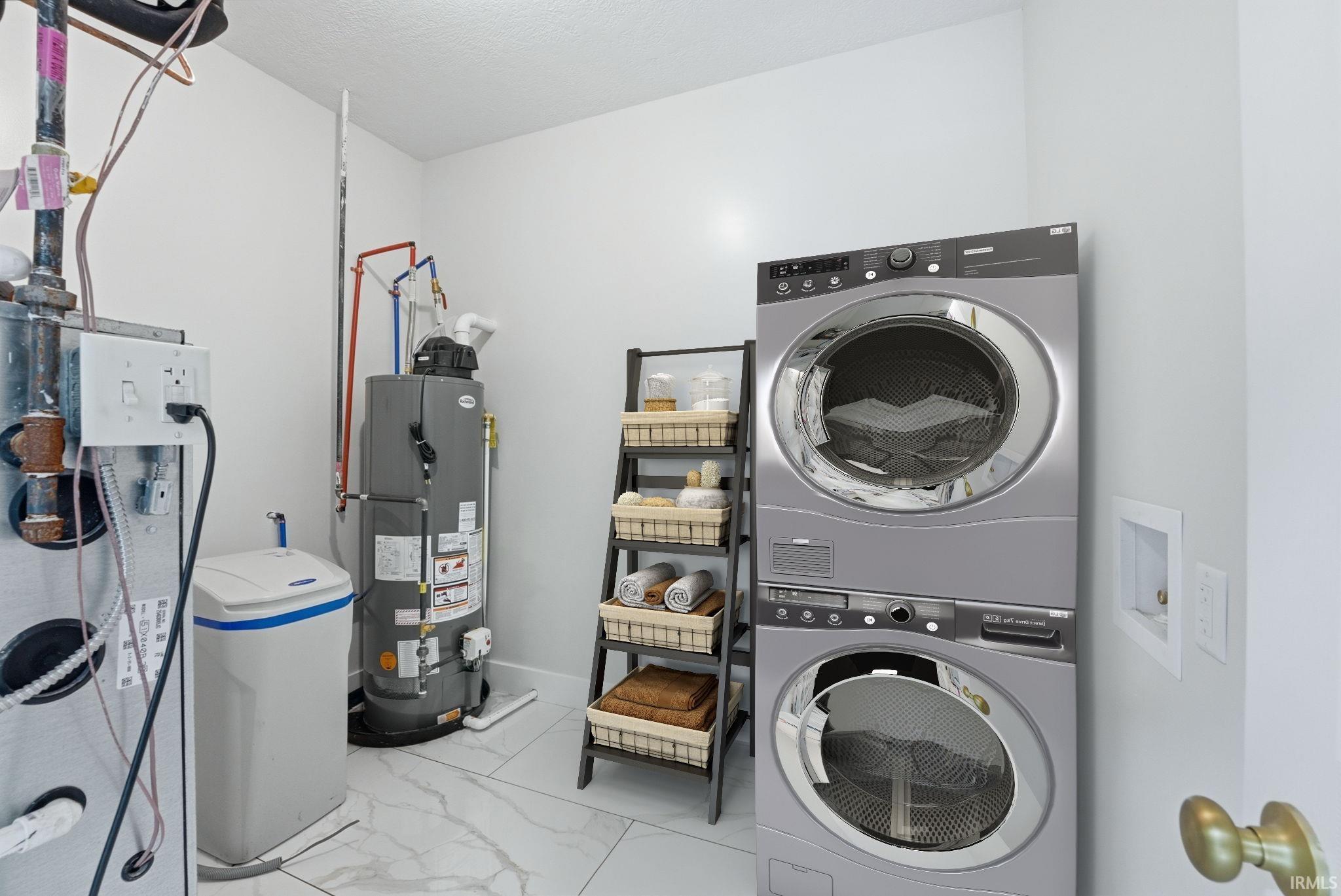 Utility space featuring stacked laundry appliances and white tile flooring