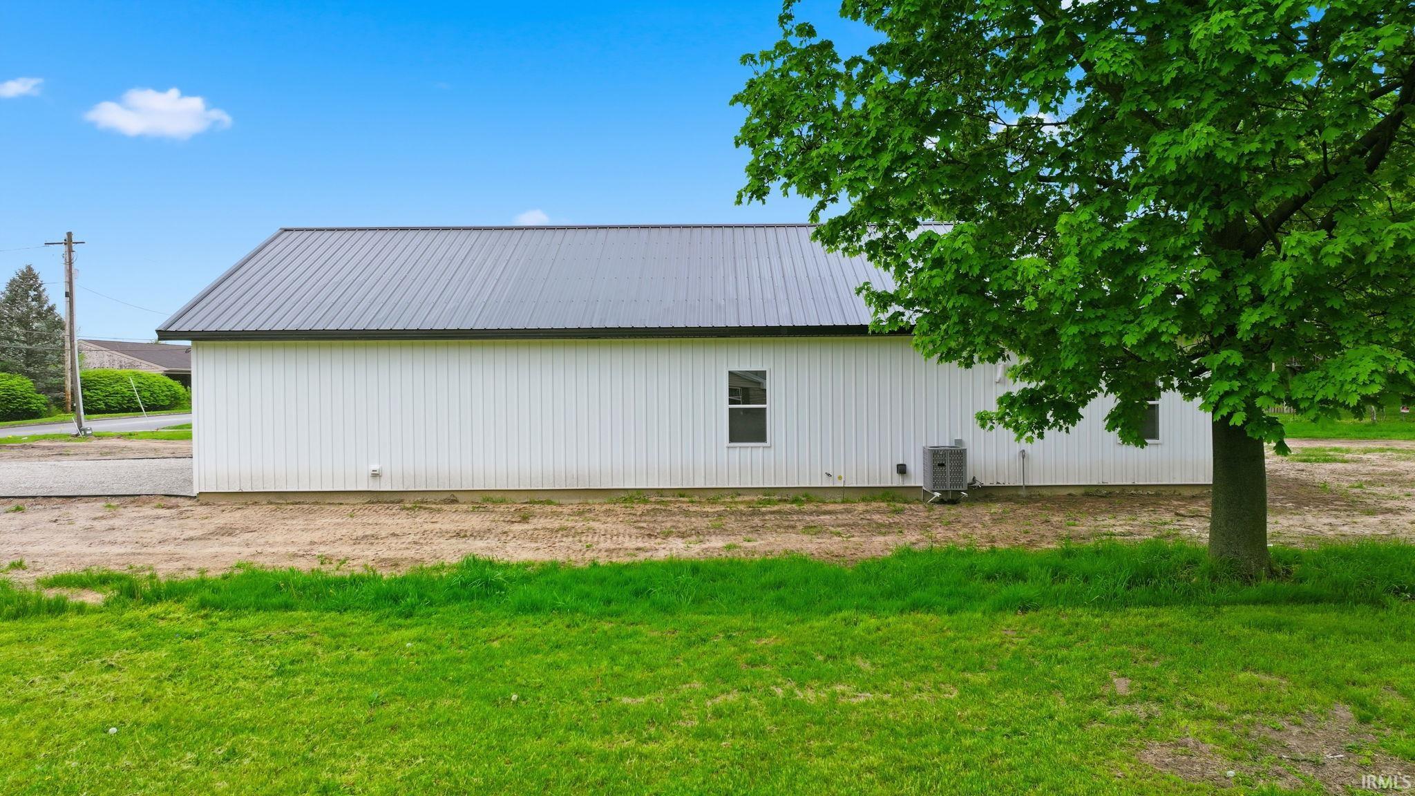 White vertical siding exterior with a dark metal roof
