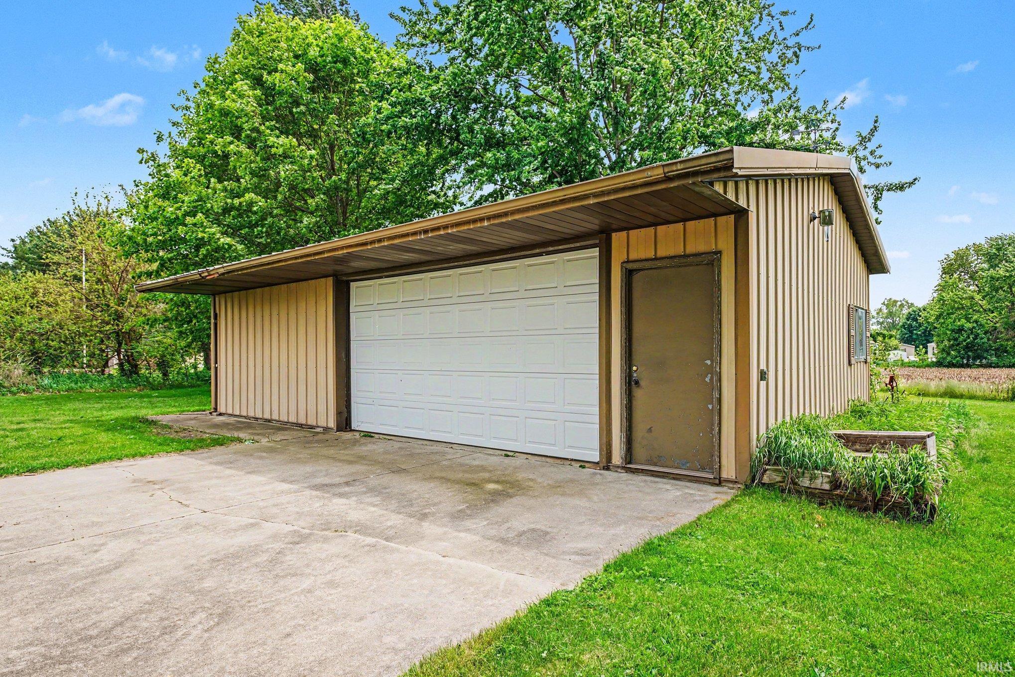 Detached garage structure featuring a large overhead door and a separate entry door