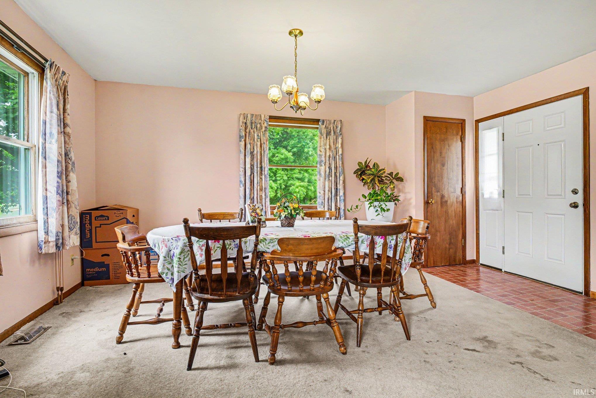 Dining area featuring a chandelier, two windows, and carpeting