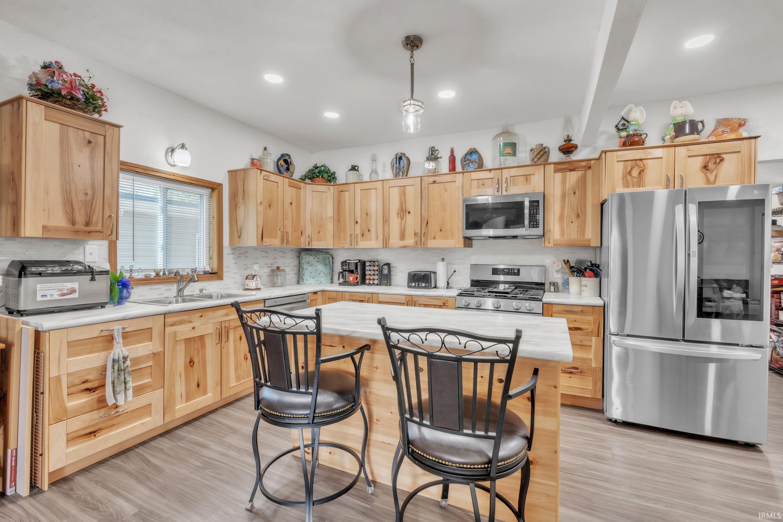 Kitchen featuring light wood cabinetry and an island with a light-toned countertop