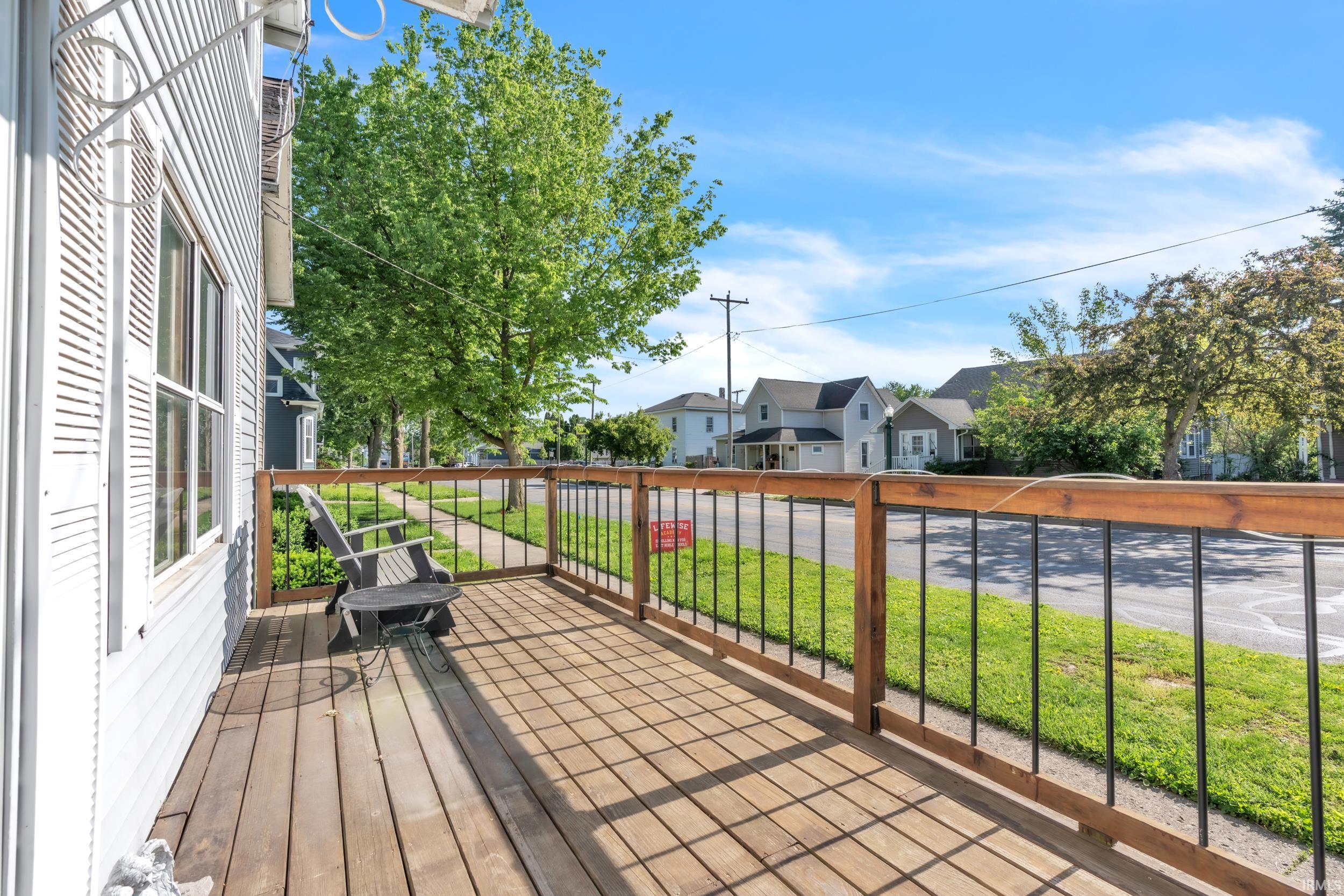 Front porch featuring wood plank decking and a wood and metal railing