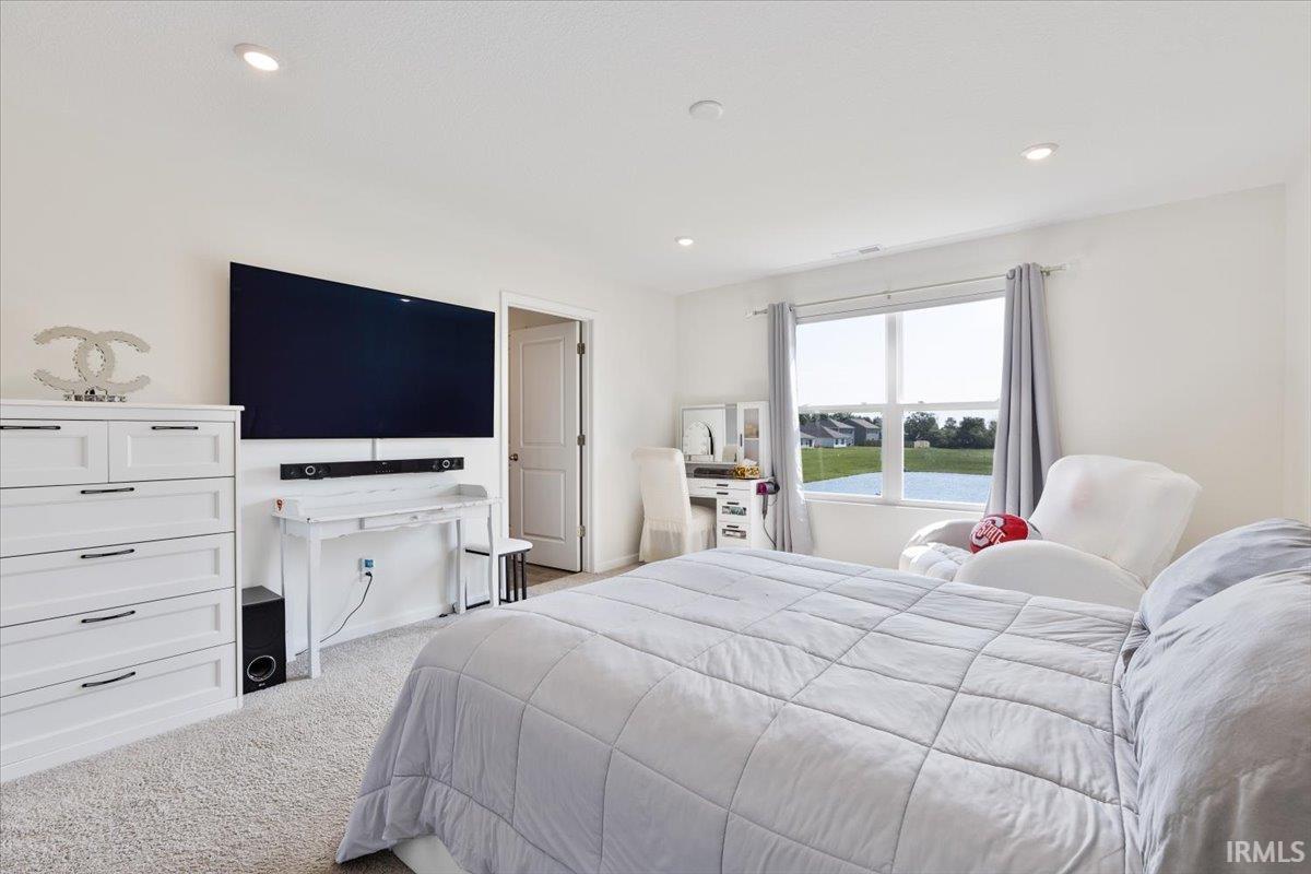 Bright bedroom with expansive window overlooking a body of water