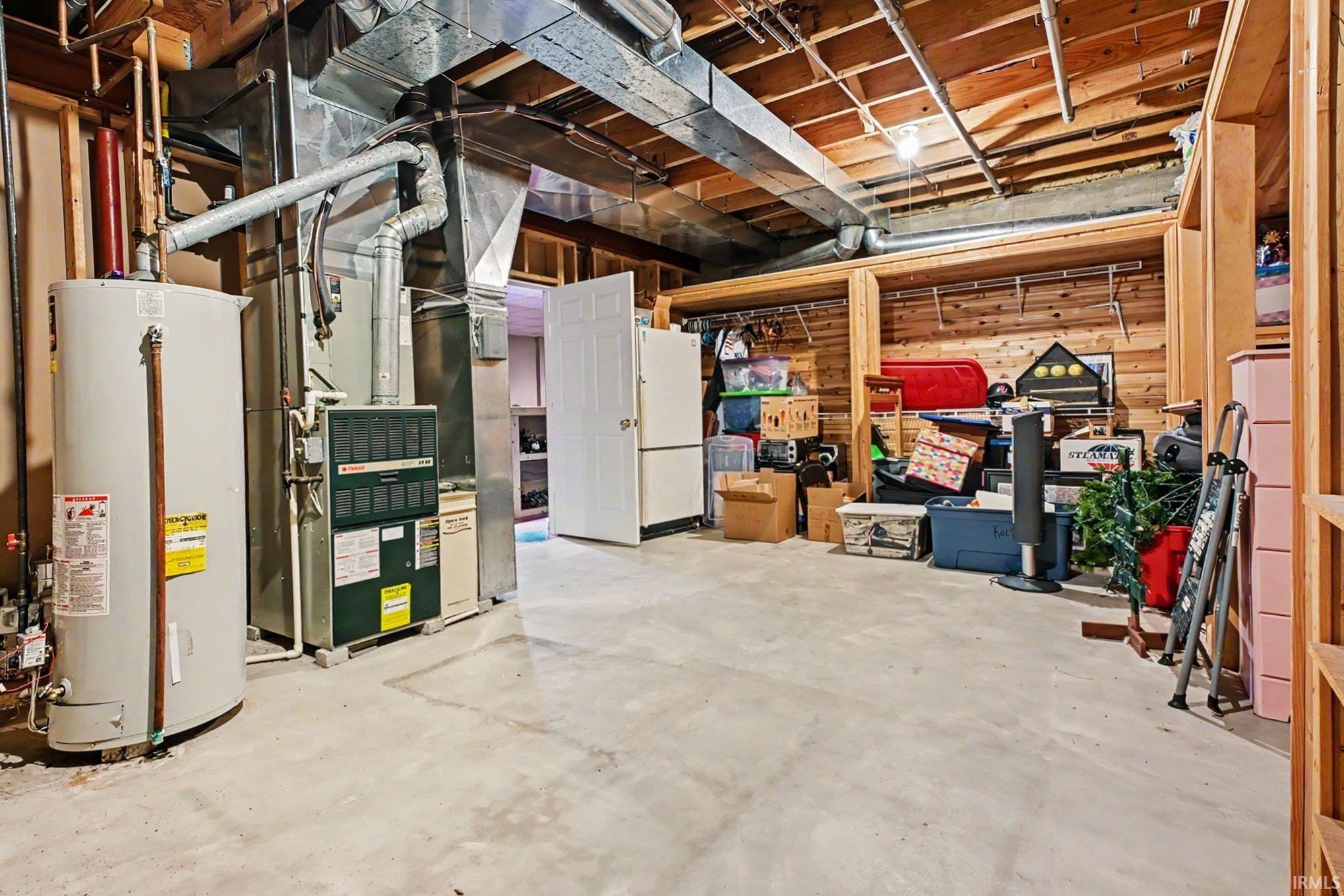Utility room featuring a water heater, furnace, and exposed ductwork