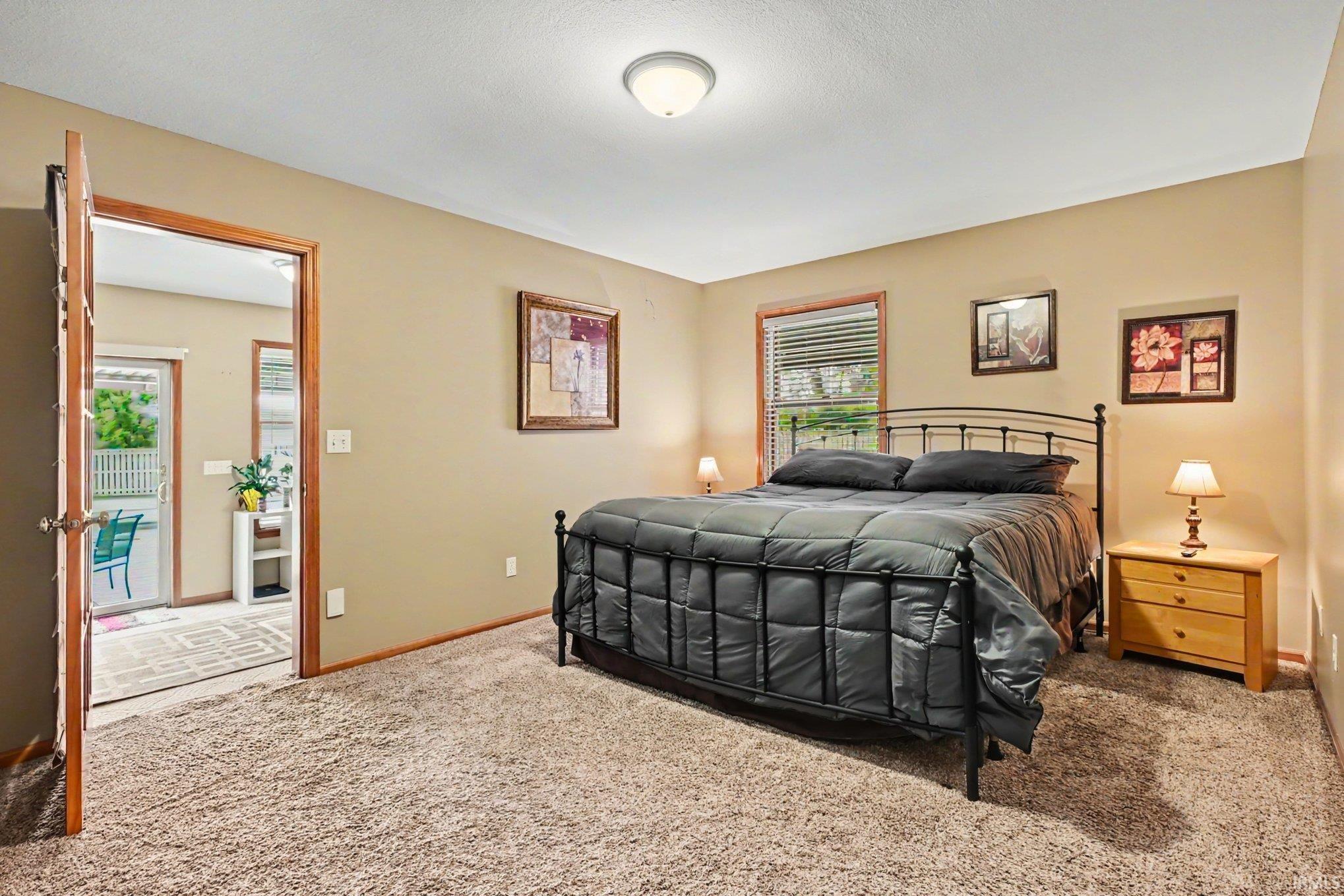 Carpeted room with a ceiling-mounted light fixture and two windows featuring blinds