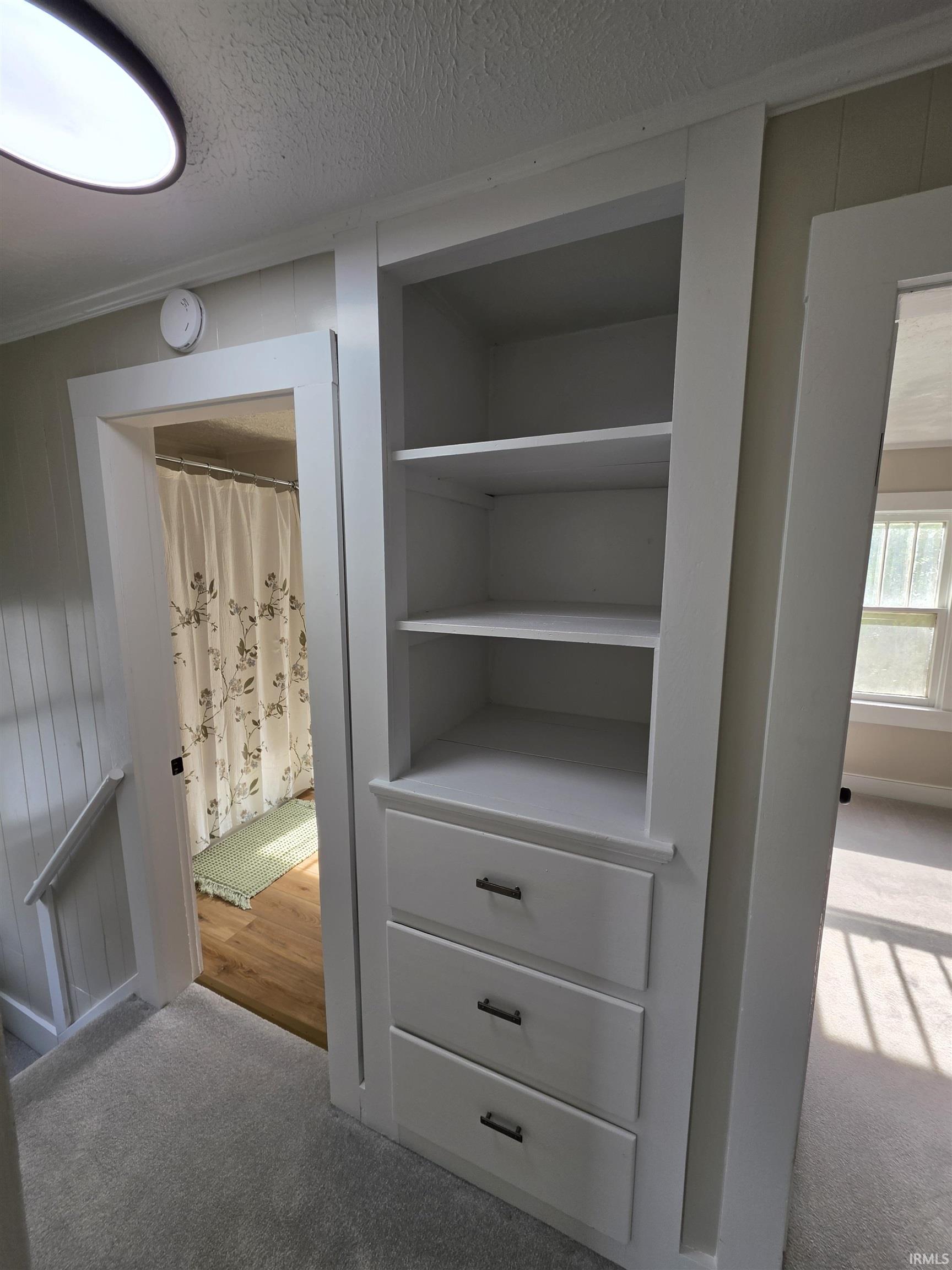 Built-in shelving unit with three drawers and open storage