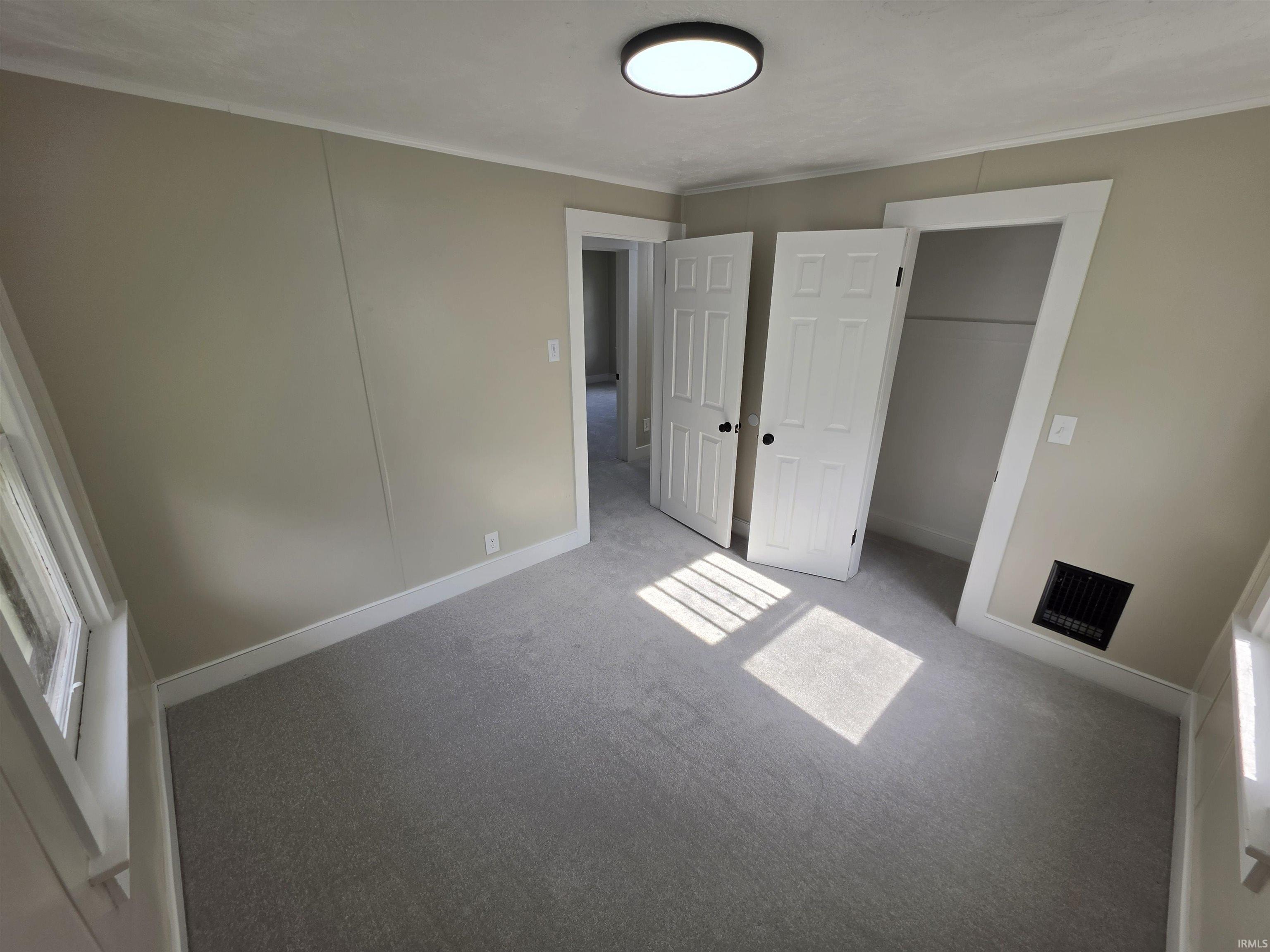 Interior room featuring light gray carpeting and neutral-toned walls