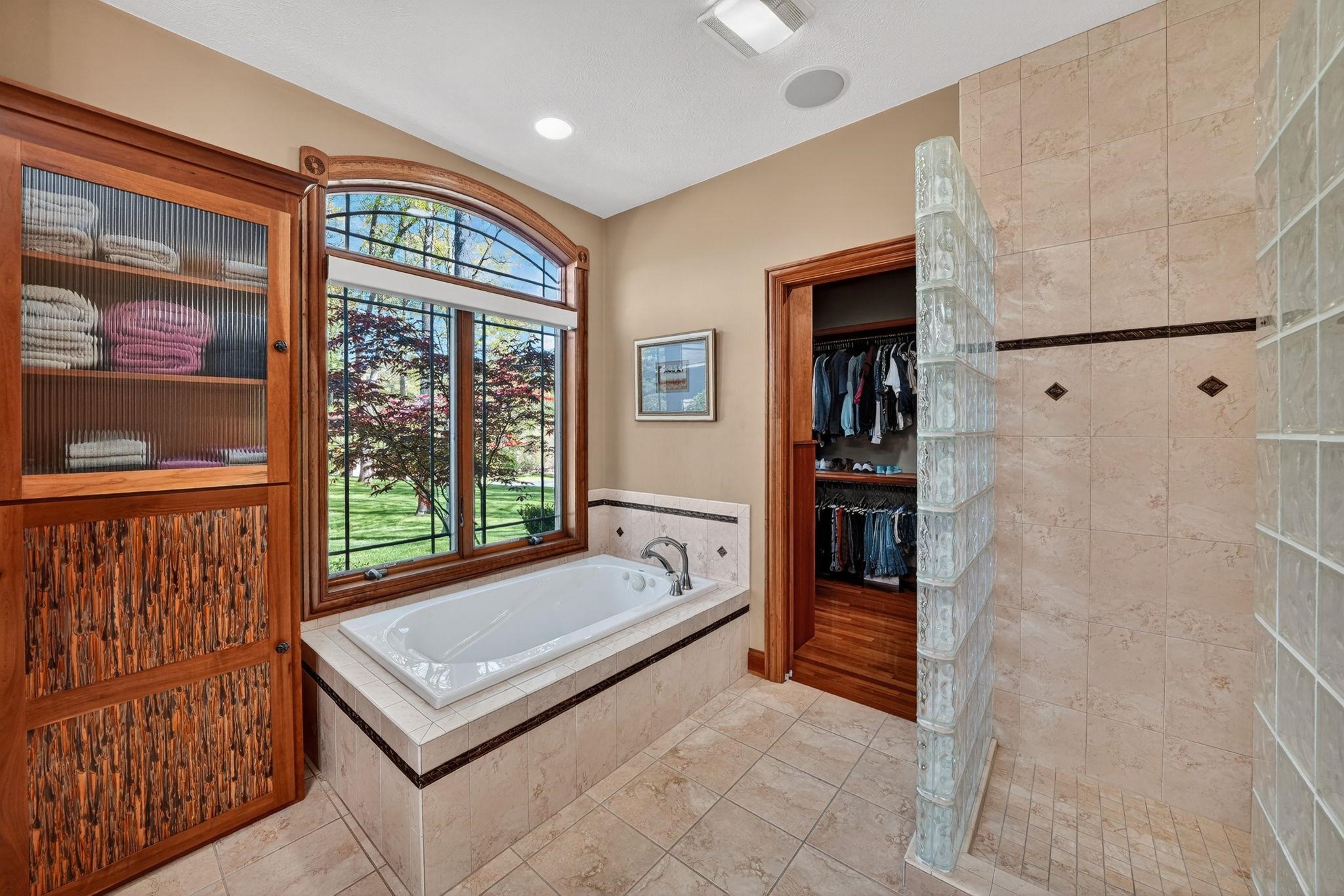 Soaking tub with surrounding tile and an arched window