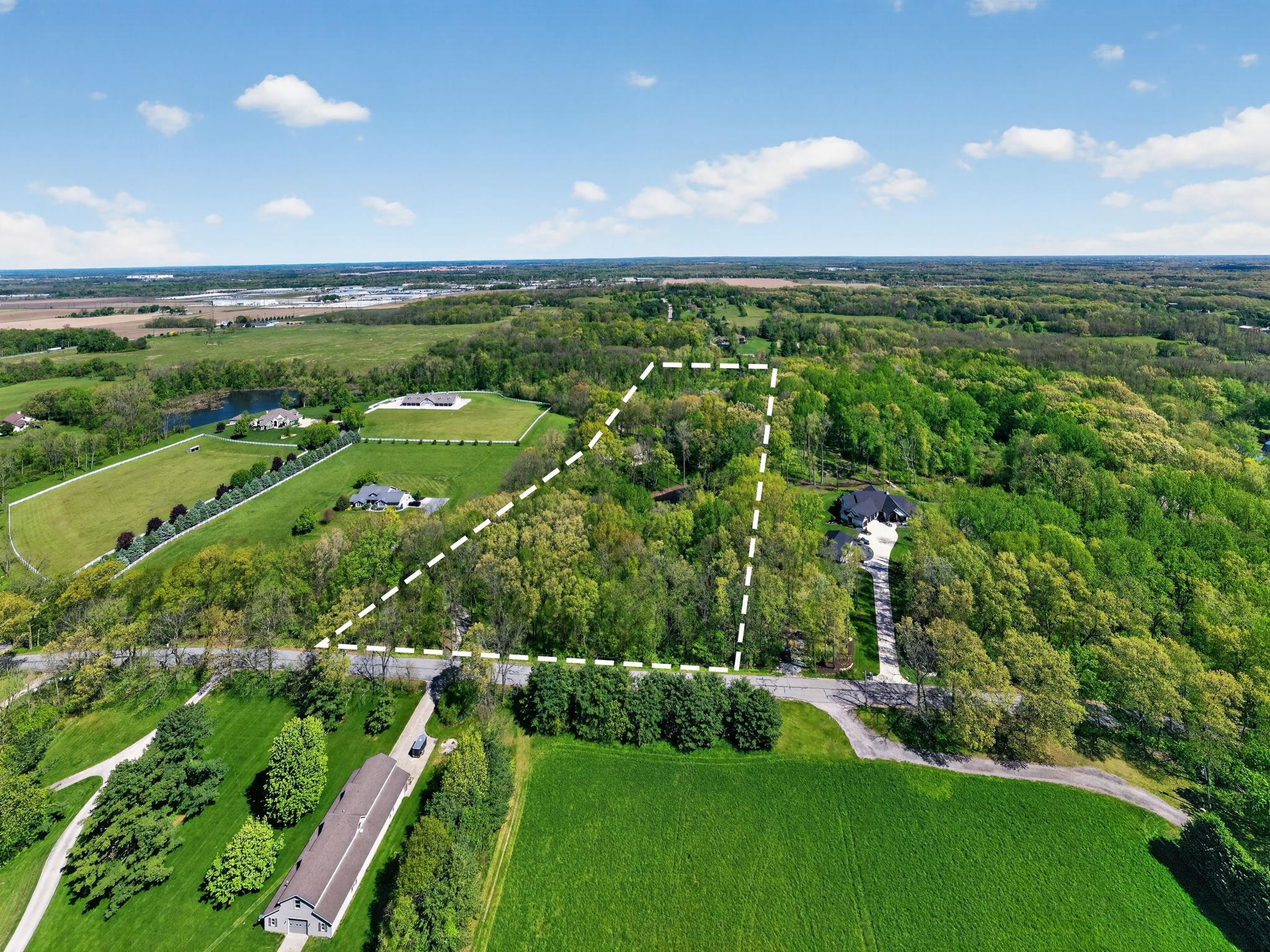 Expansive land parcel featuring a mix of mature trees and open green spaces